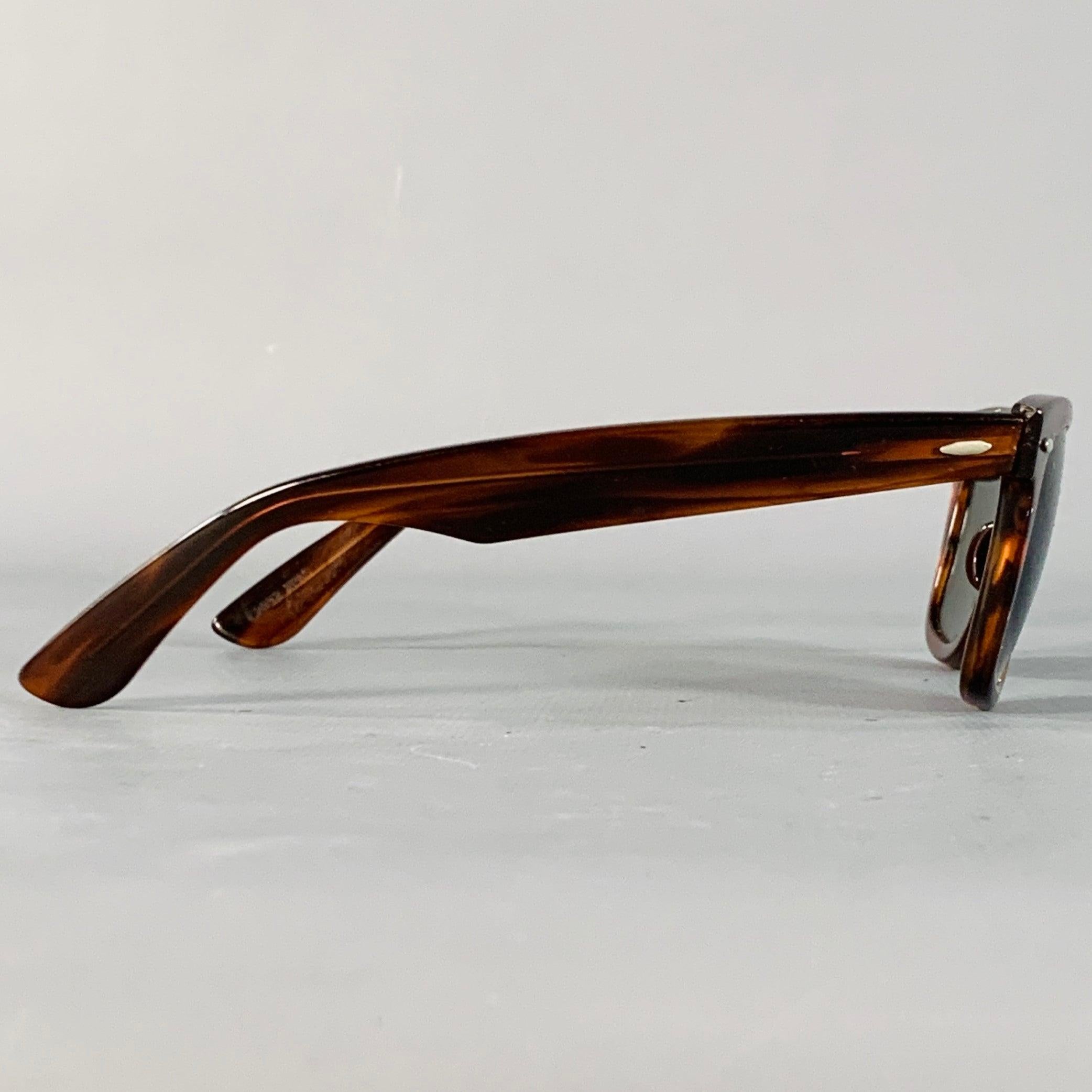 Gafas de sol vintage RAY-BAN by BAUSCH & LOMB de acetato de carey marrón con el clásico modelo Wayfarer y cristales polarizados. Viene con una funda nueva de LUXXOTICA. 

Marcado:   L2052 XPAS 

Medidas: 
  Anchura del marco: 14 cm.Altura del marco: