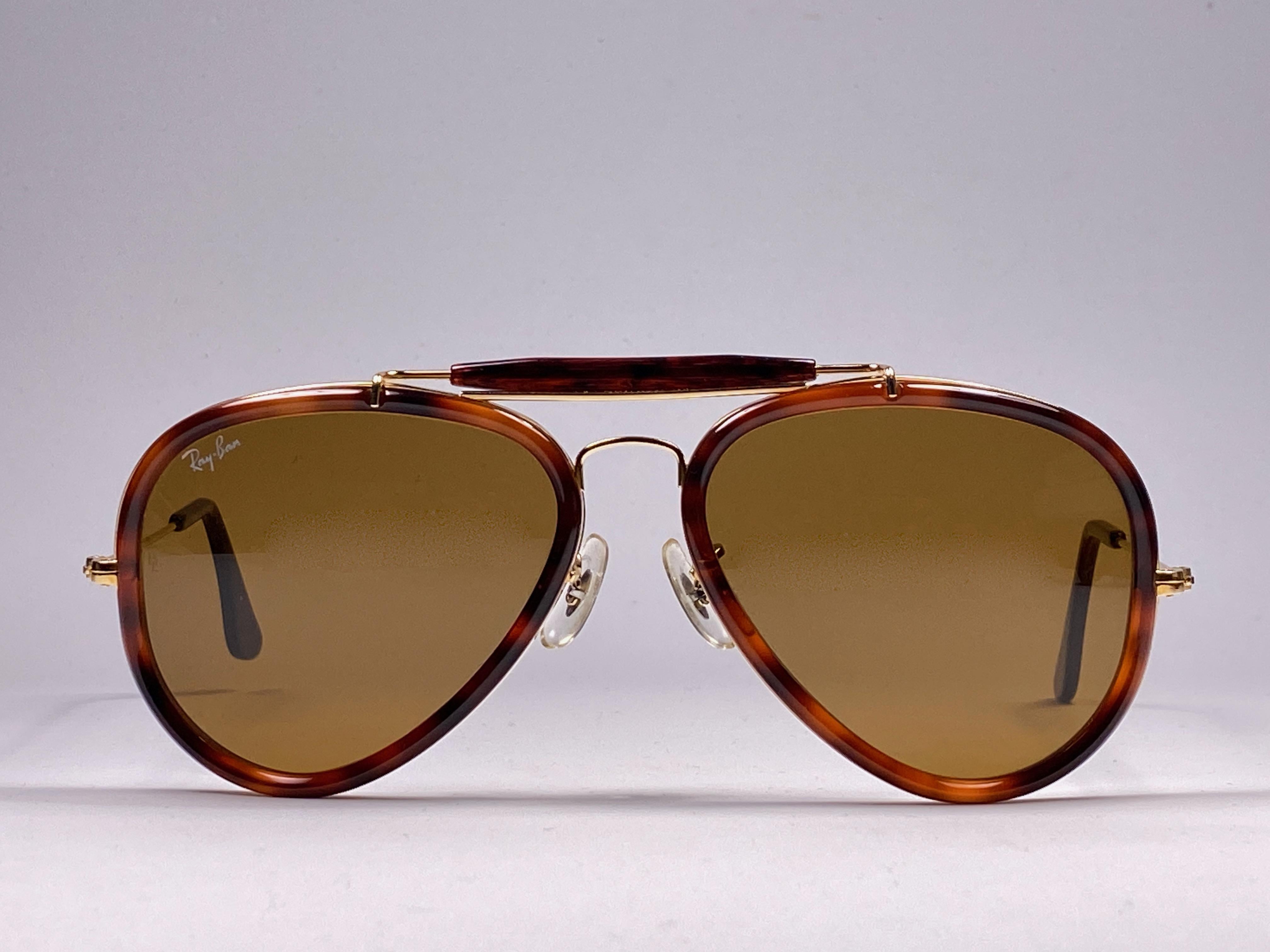 New Vintage Ray Ban dark tortoise and gold Outdoorsman 62mm with brown lenses. 

B&L etched in both lenses. 

Please notice this pair may have minor sign of wear due to nearly 30 years of storage. 

Front : 13.5 cms

Lens Width : 6.2 cms

Lens