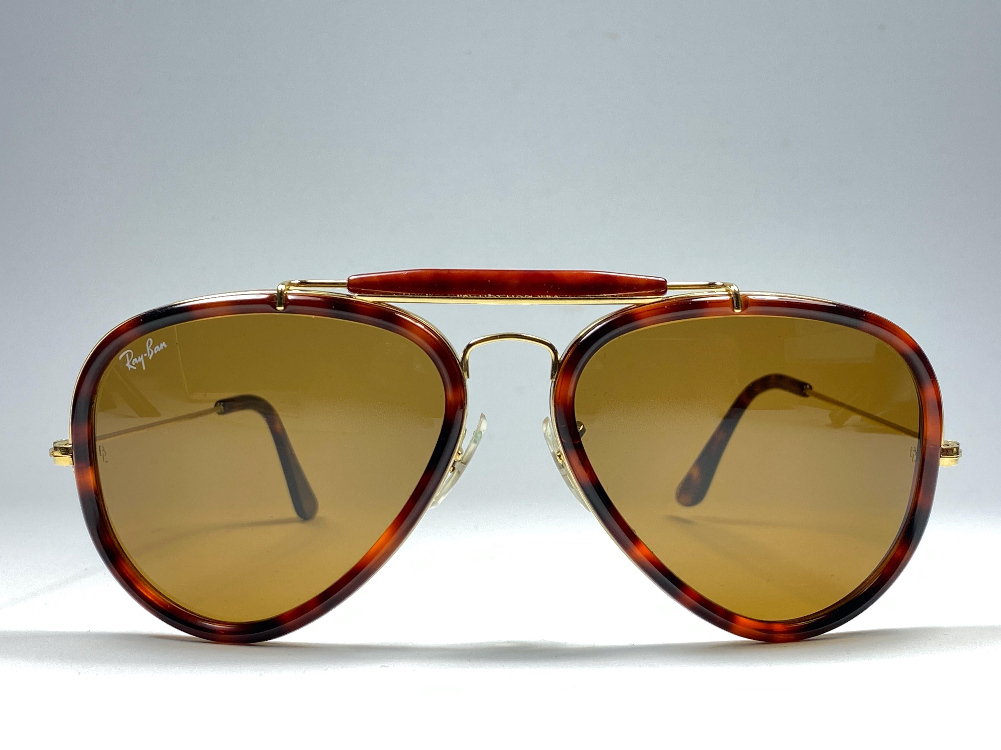 New Vintage Ray Ban Schildpatt und Gold Outdoorsman 62mm mit braunen Gläsern. 

B&L ist in beide Linsen geätzt. 

Bitte beachten Sie, dass dieses Paar aufgrund der fast 30-jährigen Lagerung leichte Gebrauchsspuren aufweisen kann. 

Vorderseite :