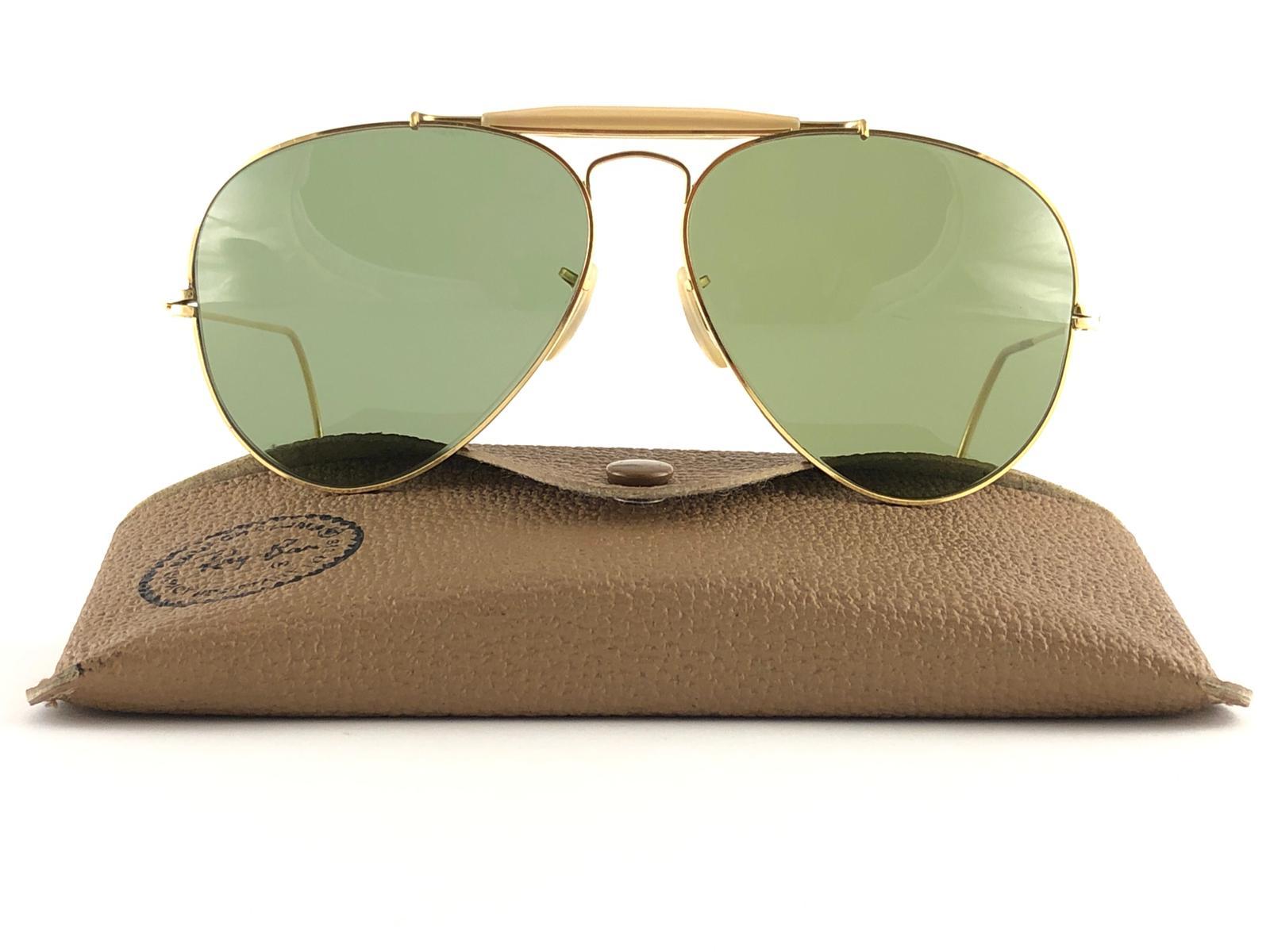 Neu Vintage Ray Ban Outdoorsman 62mm mit gewellten Bügeln. B&L geätzt in beiden RB3 grünen Linsen. 
Wird mit dem originalen Ray Ban B&L Etui geliefert. Dieses Paar weist aufgrund der fast 40-jährigen Lagerung leichte Gebrauchsspuren auf.
Ein