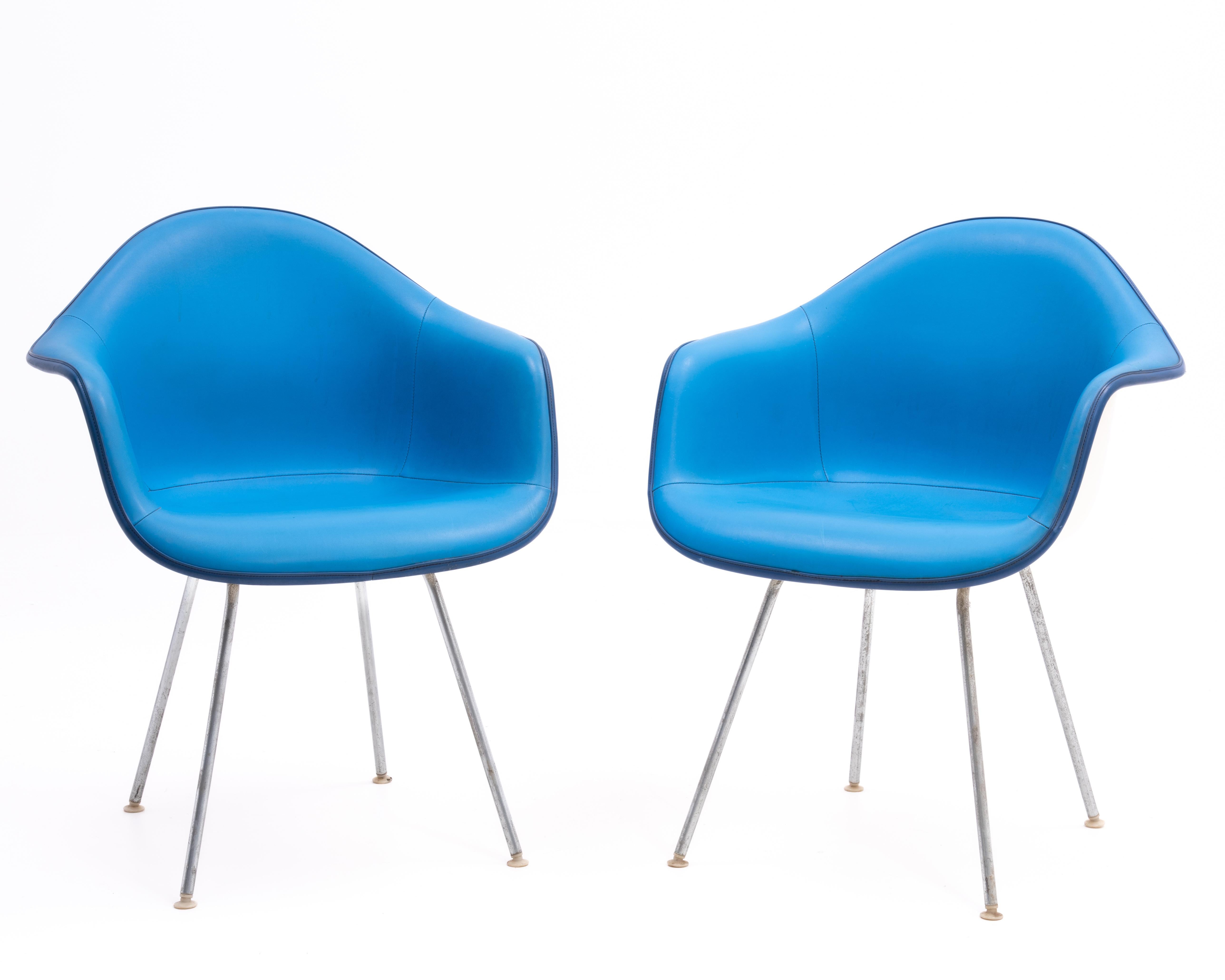 A pair of fiberglass arm shell chair designed by Ray & Charles Eames and produced by Herman Miller in 1972. The white shells contrast nicely with cerulean blue seats and royal blue piping. The white shell and contrasting seat is reminiscent of the