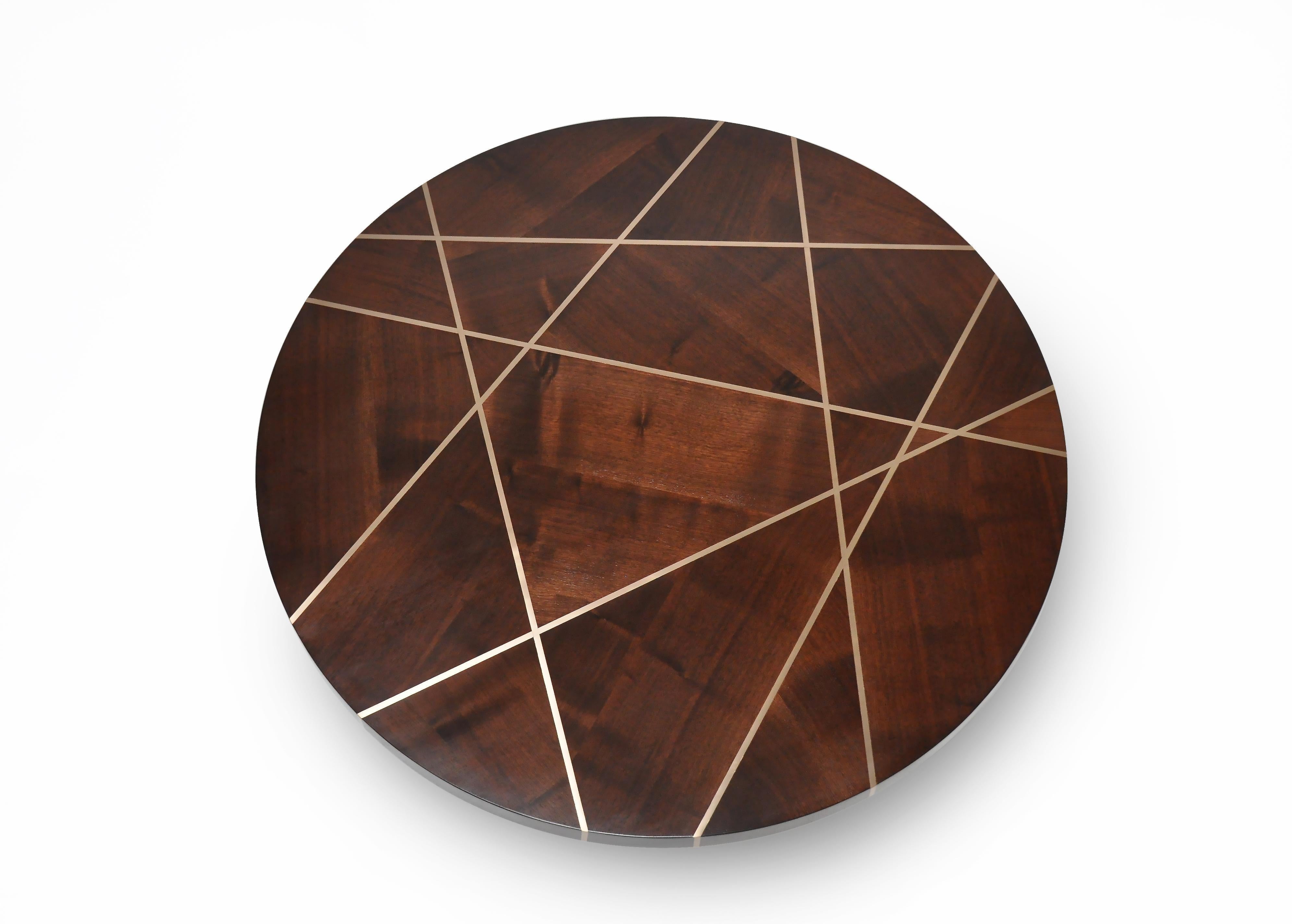 Ray cocktail table in aniline dyed walnut with bronze inlay and bronze cross base is notable piece. The walnut top is carefully configured to form geometric patterns, the wood grain is changed directionally to create a mosaic separated by Bronze