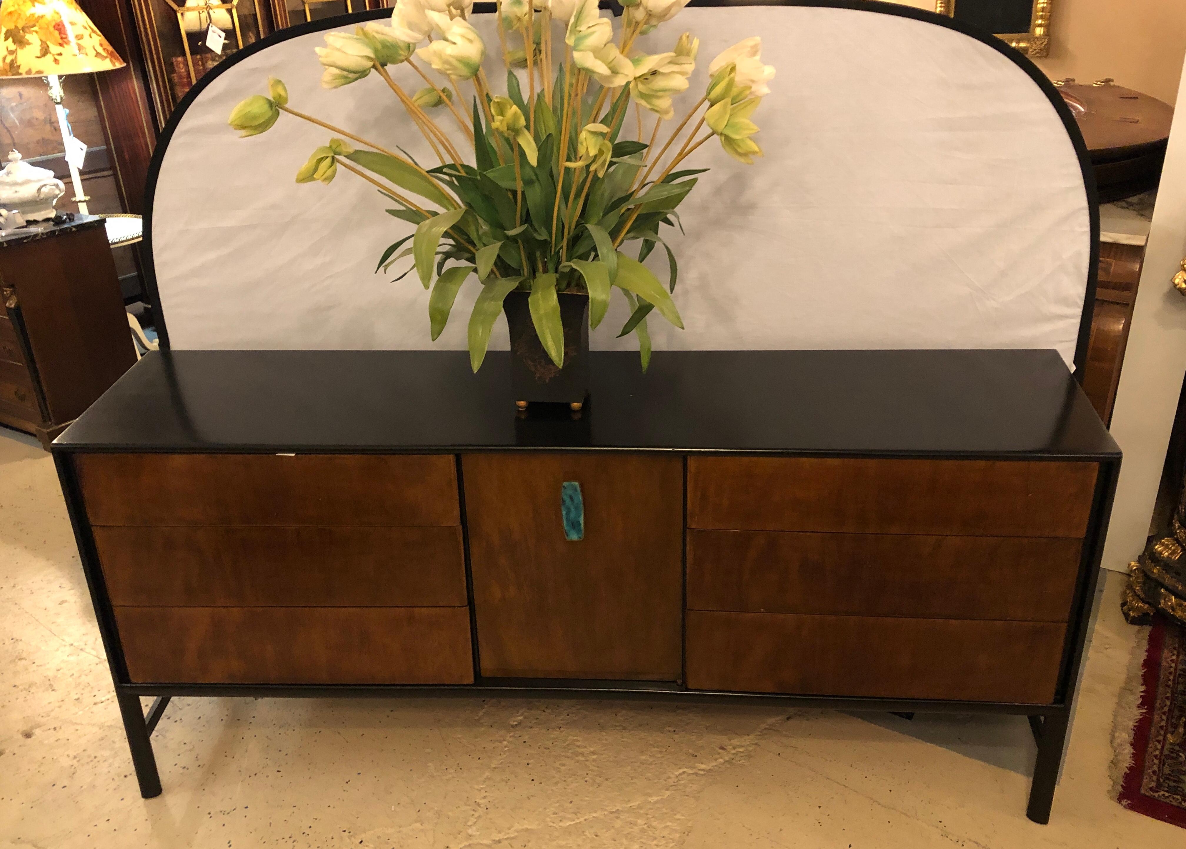 A Simply stunning John Stuart ebony and burl wood Mid-Century Modern dresser or commode, designed by Ray Sabota. This one of a kind ebony cased piece has finely polished drawer fronts the center door w its Malachite form drawer pull leading to a