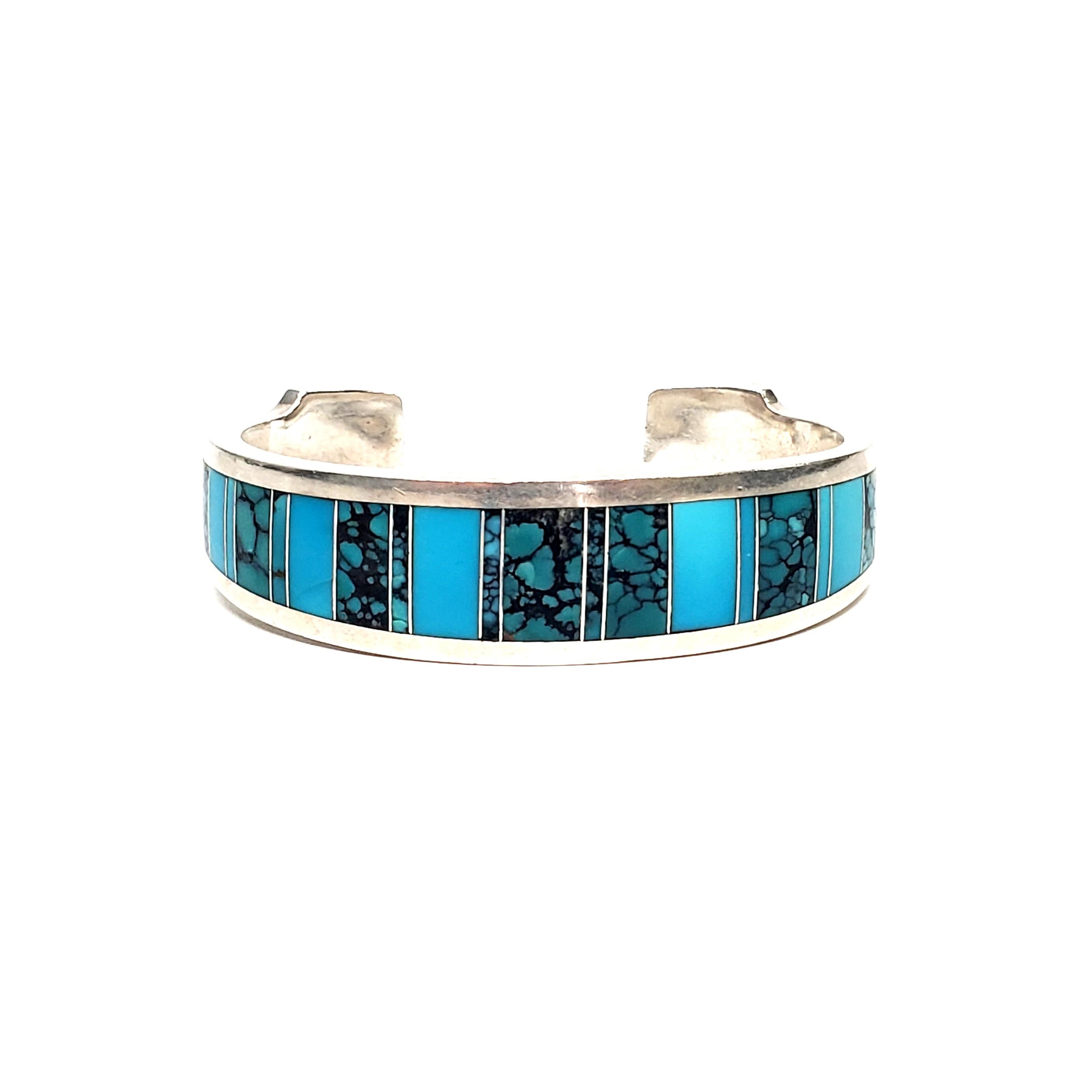 Sterling silver cuff bracelet by Native American Navajo artisan, Ray Tracey.

Beautiful inlaid turquoise, alternating between blue turquoise and veined turquoise.

Measures approx 5 3/4