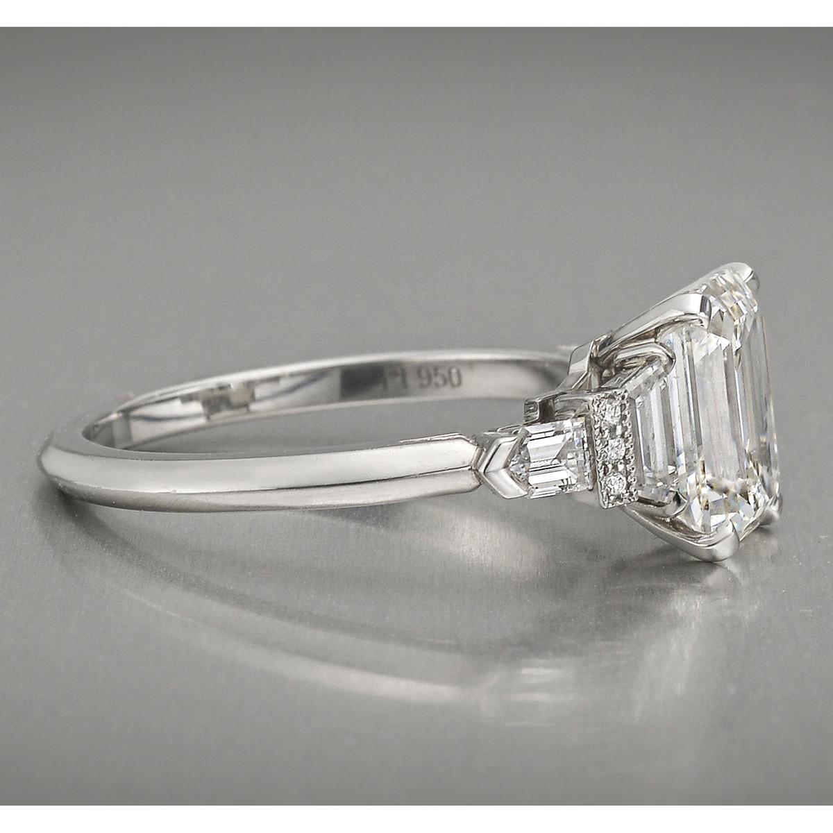 Diamond engagement ring, centering a fine near-colorless emerald-cut diamond weighing 2.09 carats flanked by trapeze, bullet and round brilliant-cut diamond accents, mounted in polished platinum.

Two trapeze-cut diamonds weighing 0.34 total carats,