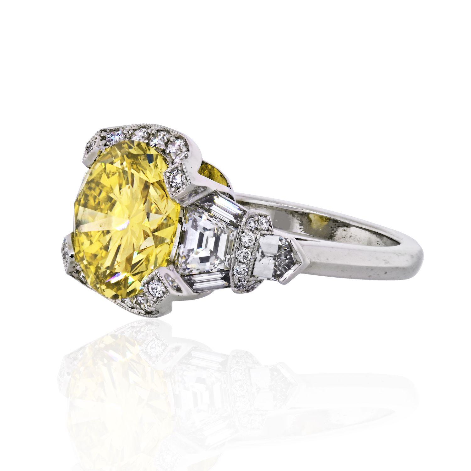 A timeless design from Raymond Yard, this 5.02-carat Fancy Intense Yellow Round Cut diamond ring is a true classic. This estate engagement ring is the type of ring that can be worn for any occasion. The diamond is a rare 5 carat fancy intense round