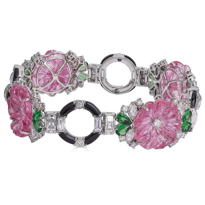 Multicolored gemstone flower bracelet, featuring carved pink tourmaline flowers accented by pear-shaped tsavorites and mixed-cut diamonds, mounted in platinum with carved black onyx.

Designed by Raymond C. Yard
Four carved pink tourmaline flowers