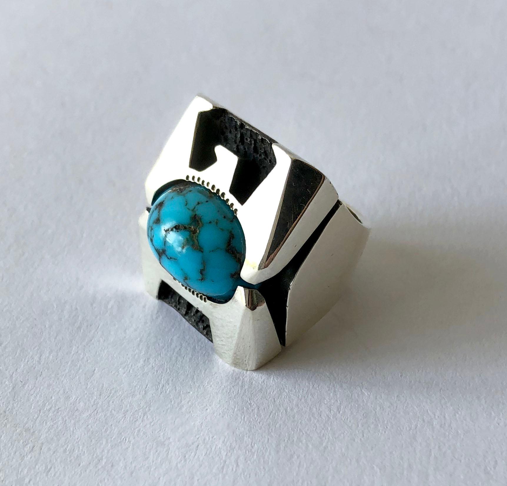 Faceted sterling silver Thunderbird ring with centered turquoise, created by Raymond Graves of Scottsdale, Arizona.  The Thunderbird is considered a spiritual, supernatural being of power and protection.  Ring is heavy and large in scale measuring a
