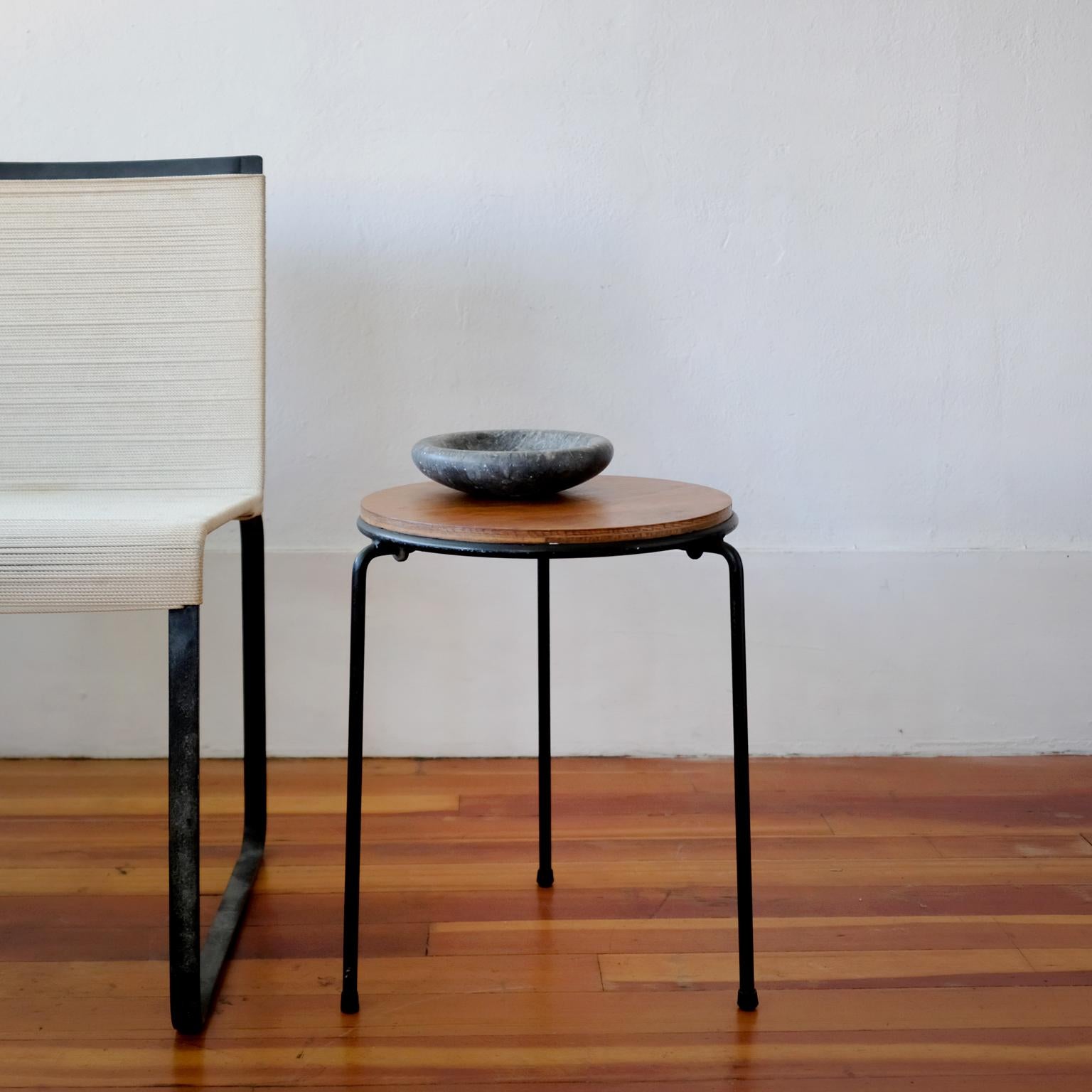 A pair of tripod iron and walnut stackable tables or stools by noted architect Raymond Jean of New York. Floating walnut top and clever rubber rings to prevent damage while stacking, American, 1950s.

The design was featured in the renowned Esempi