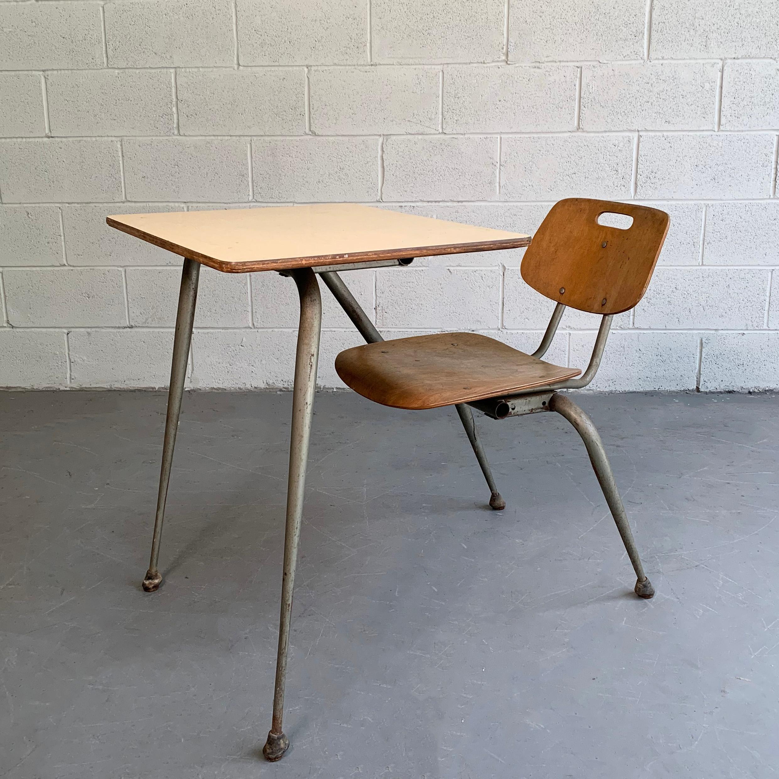 Midcentury, Machine Age, desk and chair ensemble by Raymond Loewy for Brunswick features a tapered, tubular steel frame with contoured maple ply chair with attached laminate desk top. The desk top measures 24 wide x 20 deep inches and the seat