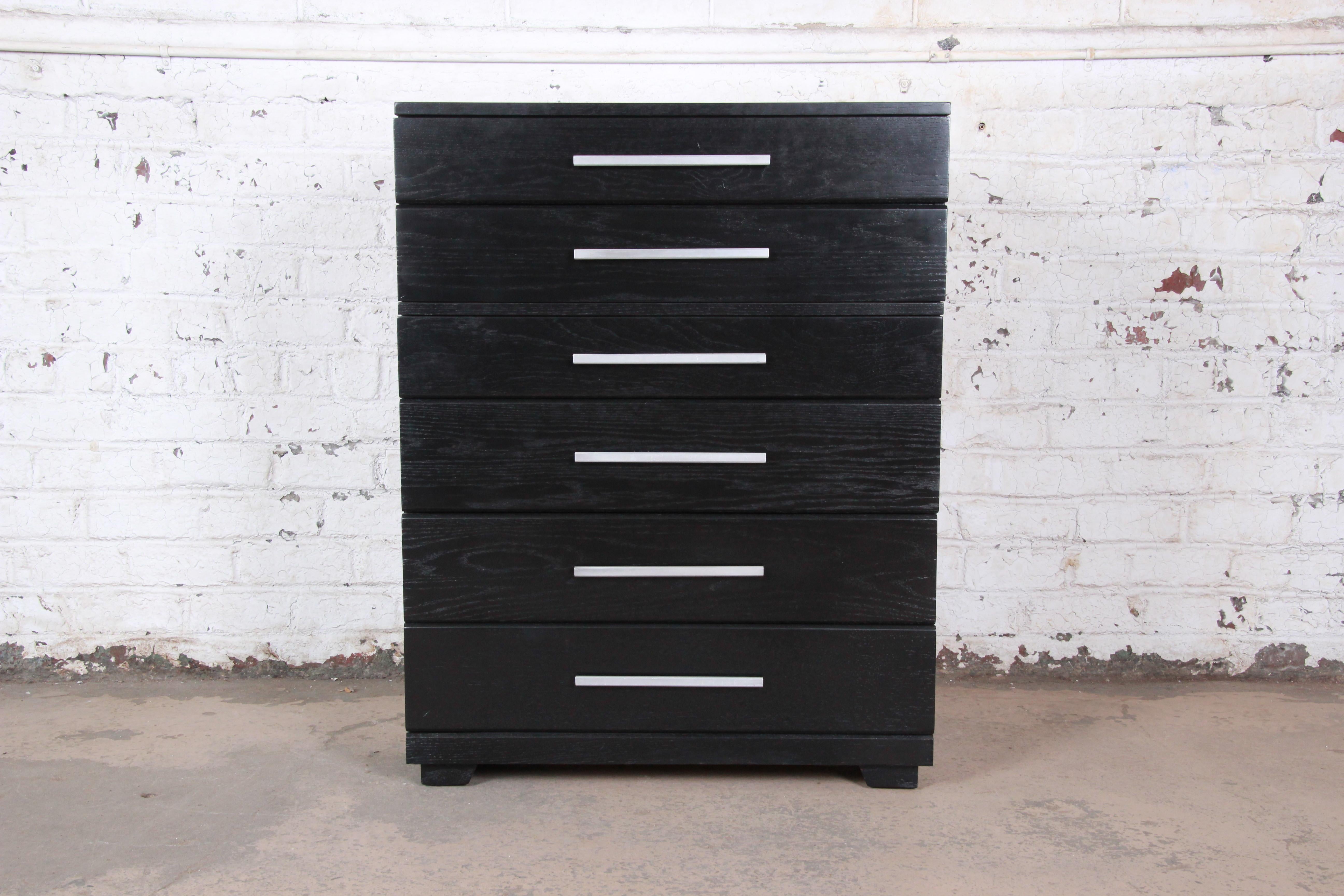 A gorgeous Mid-Century Modern highboy dresser designed by Raymond Loewy for Mengel Furniture. The dresser features stunning oakwood grain, with a newly ebonized finish. It offers ample storage, with six deep drawers each with original aluminum