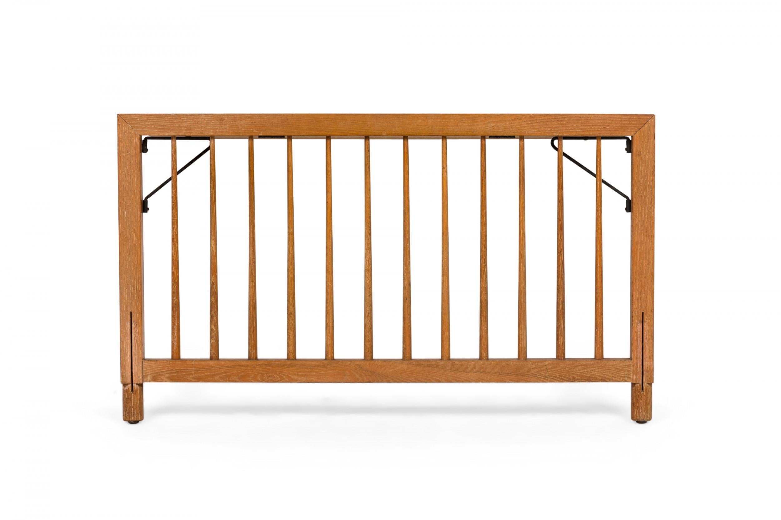 Mid-Century American (circa early 1950s) single-size spindle style wooden head and footboard with extending shelf in a streamlined, functional style with a proprietary orange wash finish which allows the wood grain to show through. (RAYMOND LOEWY