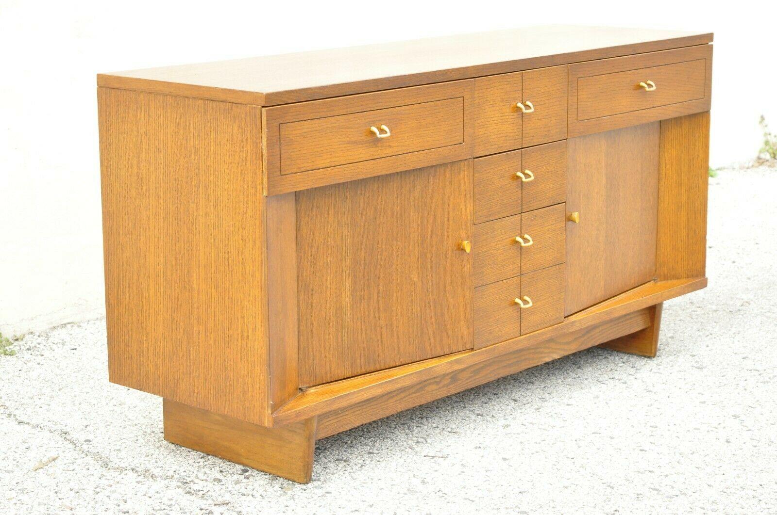 Raymond Loewy Mengel Mid Century Modern Sculpted Oak Buffet Credenza. Item features a beautiful wood grain, 2 swing doors, original stamp, 5 drawers, quality American craftsmanship, sleek sculptural form. *Color is a bit more brown indoors. Mid 20th