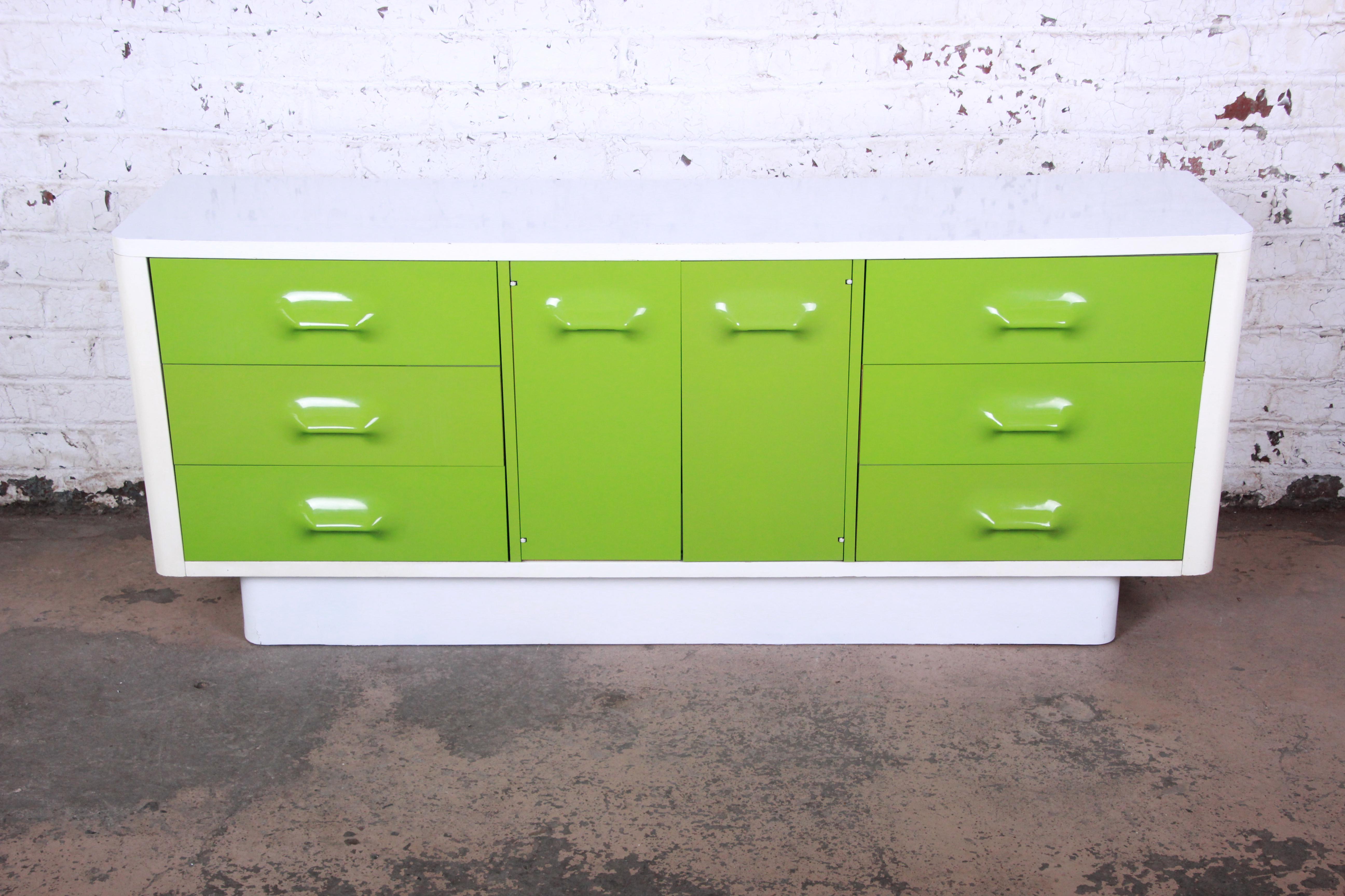 Offering a rare and unique Raymond Loewy style Mid-Century Modern credenza or media cabinet by Broyhill Premier. The credenza features Space Age injection molded vibrant green plastic drawer fronts, with a white laminate top over lacquered case. It