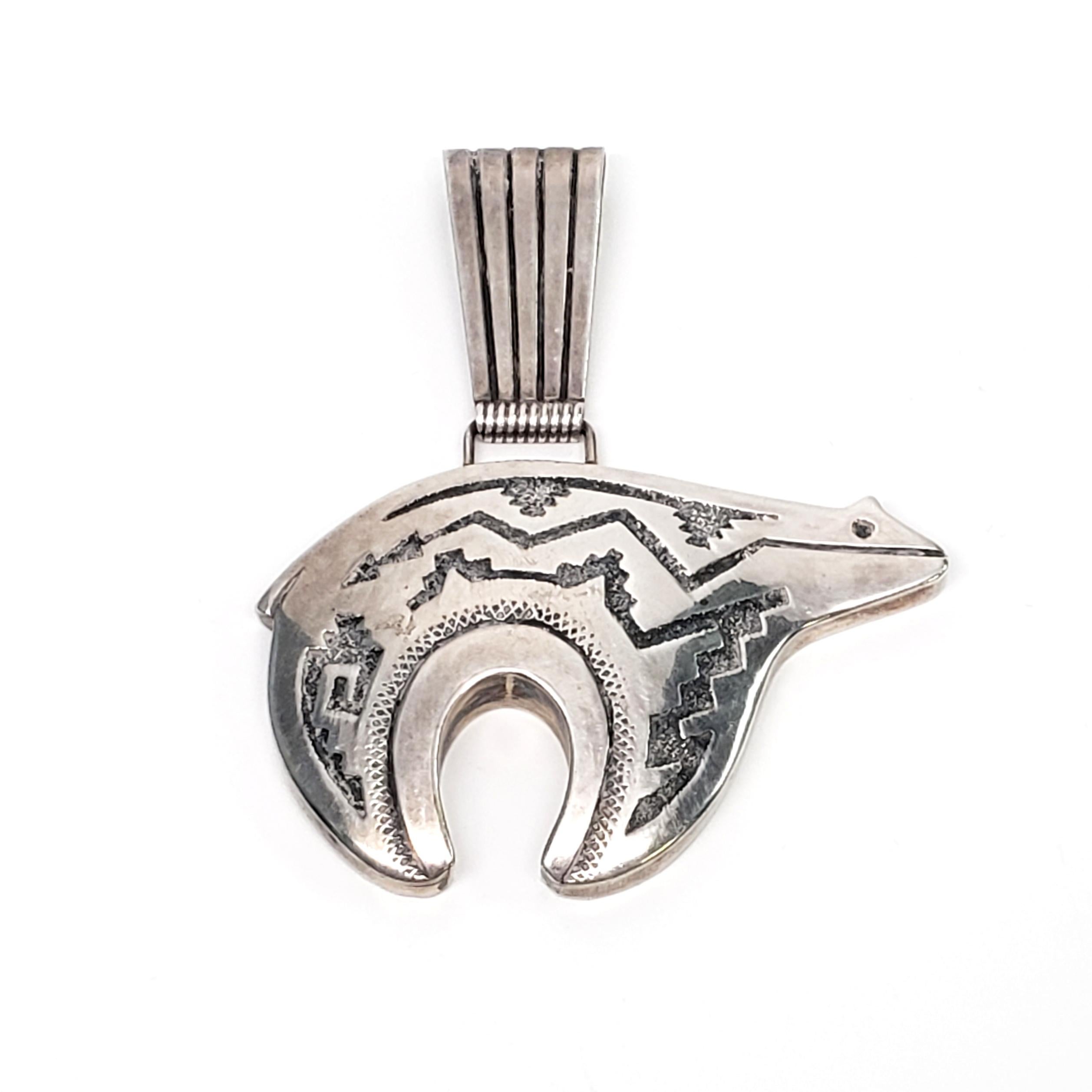 Sterling silver bear pendant by Native American Navajo artisan, Raymond Secatero.

Beautifully handcrafted bear pendant with tribal etched designs. The bear symbolizes a fierce warrior and great hunter in Native American culture.

Measures approx 2