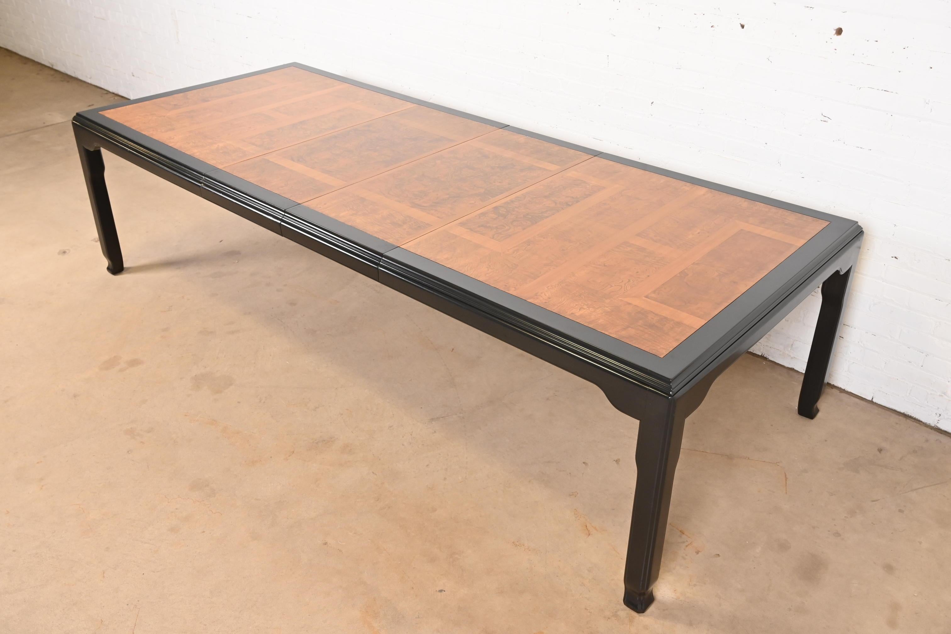 A gorgeous mid-century modern Hollywood Regency Chinoiserie extension dining table

By Raymond Sobota for Century Furniture

USA, Circa 1970s

Burl wood top with parquet design, with black lacquered trim and legs.

Measures: 76.25