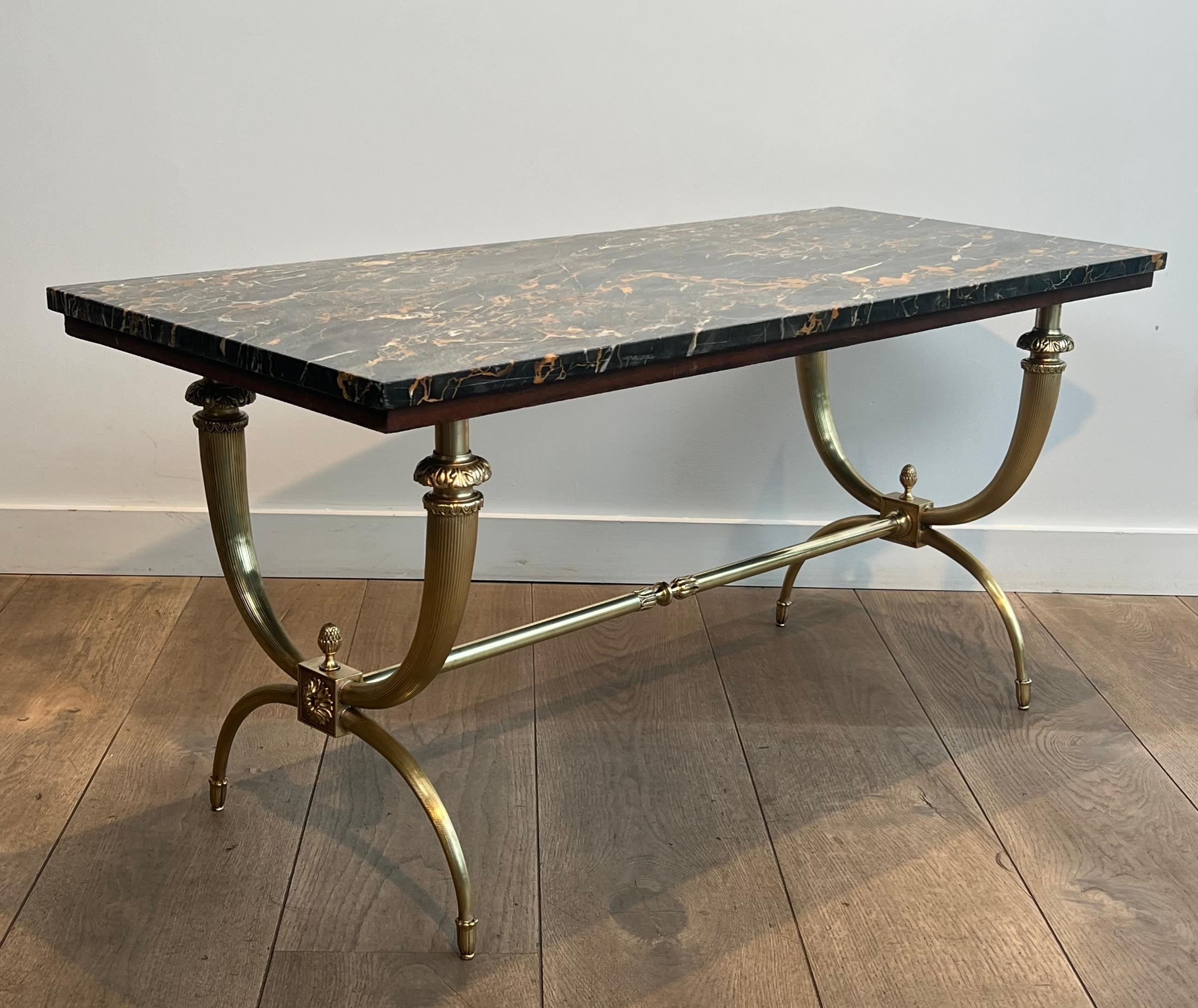 Questo grazioso ed elegante tavolino da caffè in stile neoclassico è realizzato in bronzo e ottone con un piano in marmo nero e dorato. Si tratta di un'opera francese del famoso designer Raymond Subes. Circa 1940