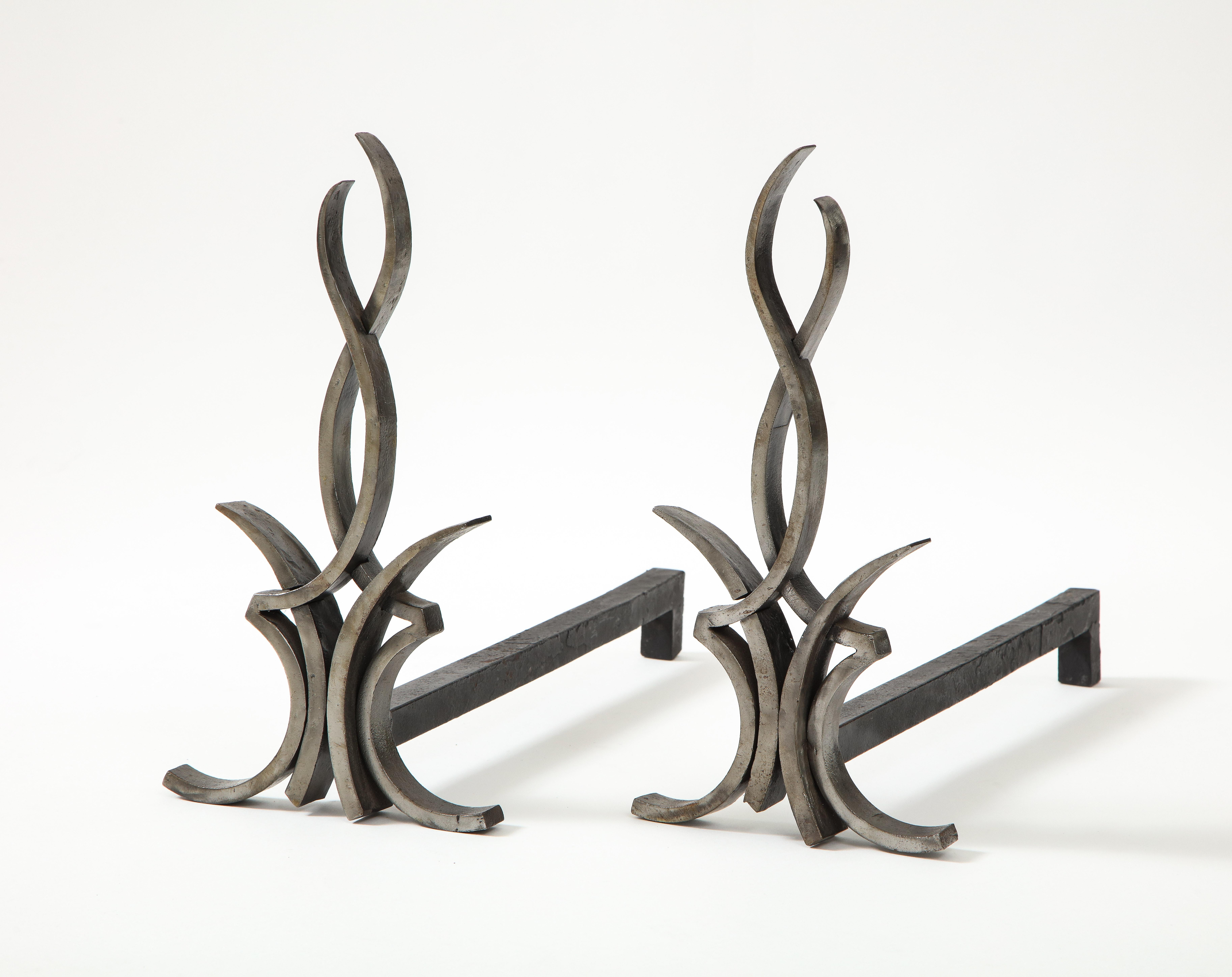Französische, handgeschmiedete Art-Déco-Stahl-Andirons mit stilisiertem Flammendesign und geschwärzter Eisenrückwand. Professionell gereinigt.