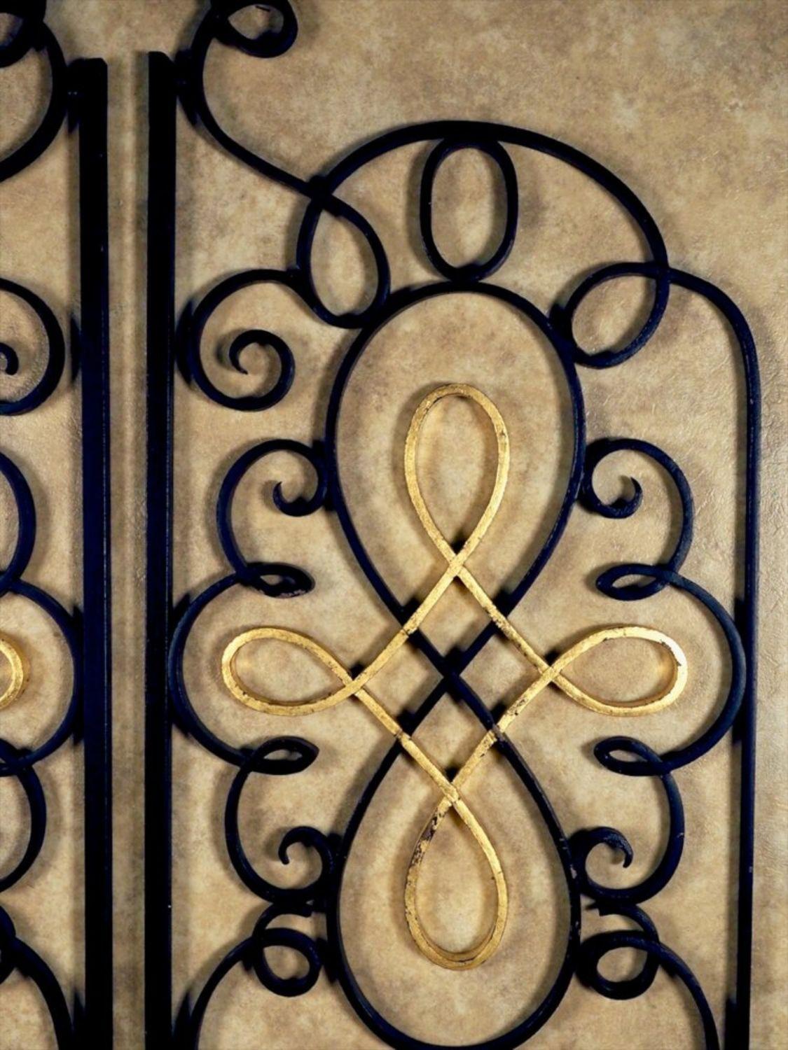 French 1940s pair of forged iron and gilt grilles/gates by Raymond Subes. Measures: 41” wide overall x 65” high at peak.