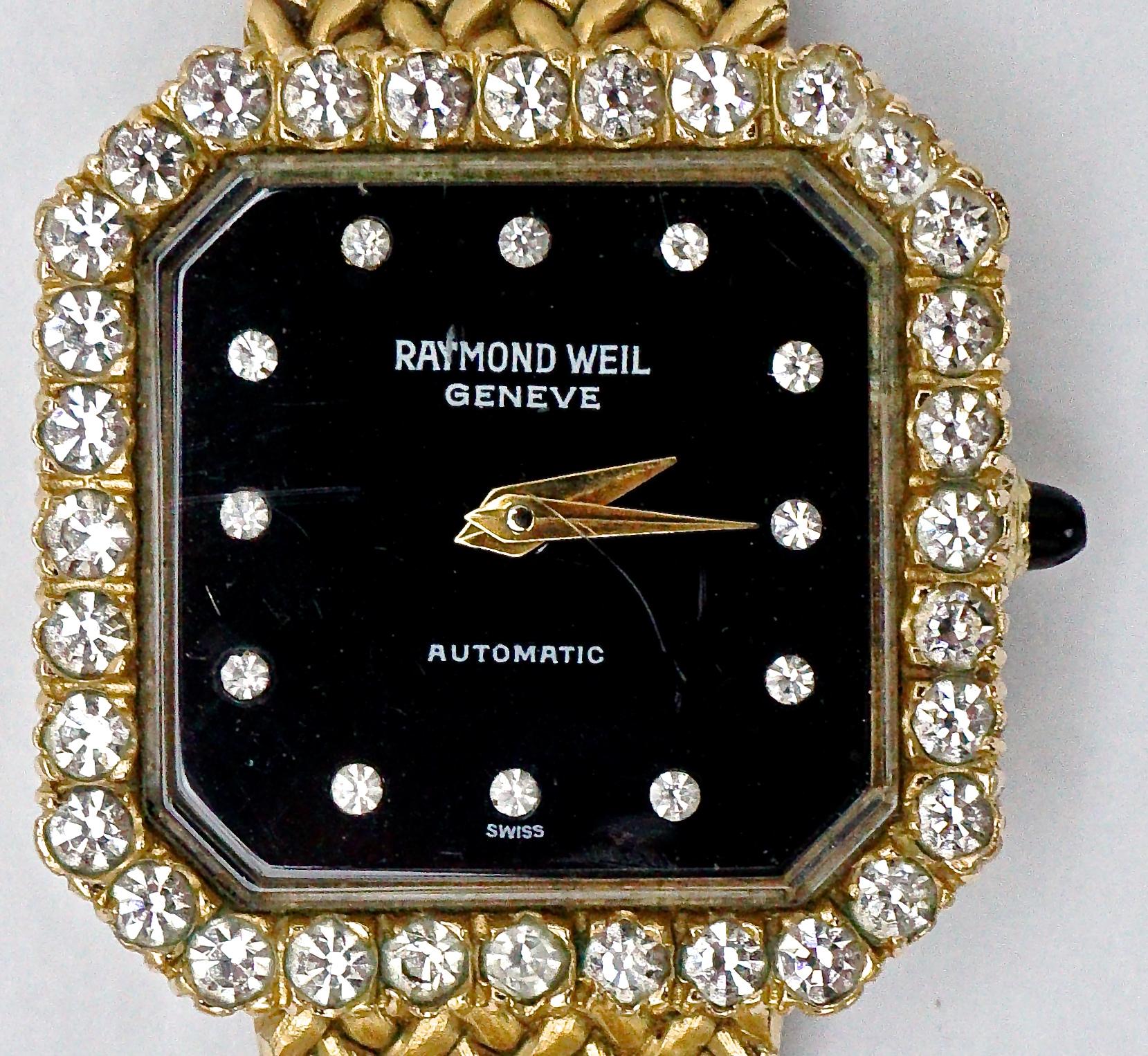 Raymond Weil Geneve automatic Swiss gold plated watch in good working condition, with a herringbone design adjustable band, and black face with rhinestones for numbers. The face also has a rhinestone surround. Measuring length 20cm / 7.87 inches by