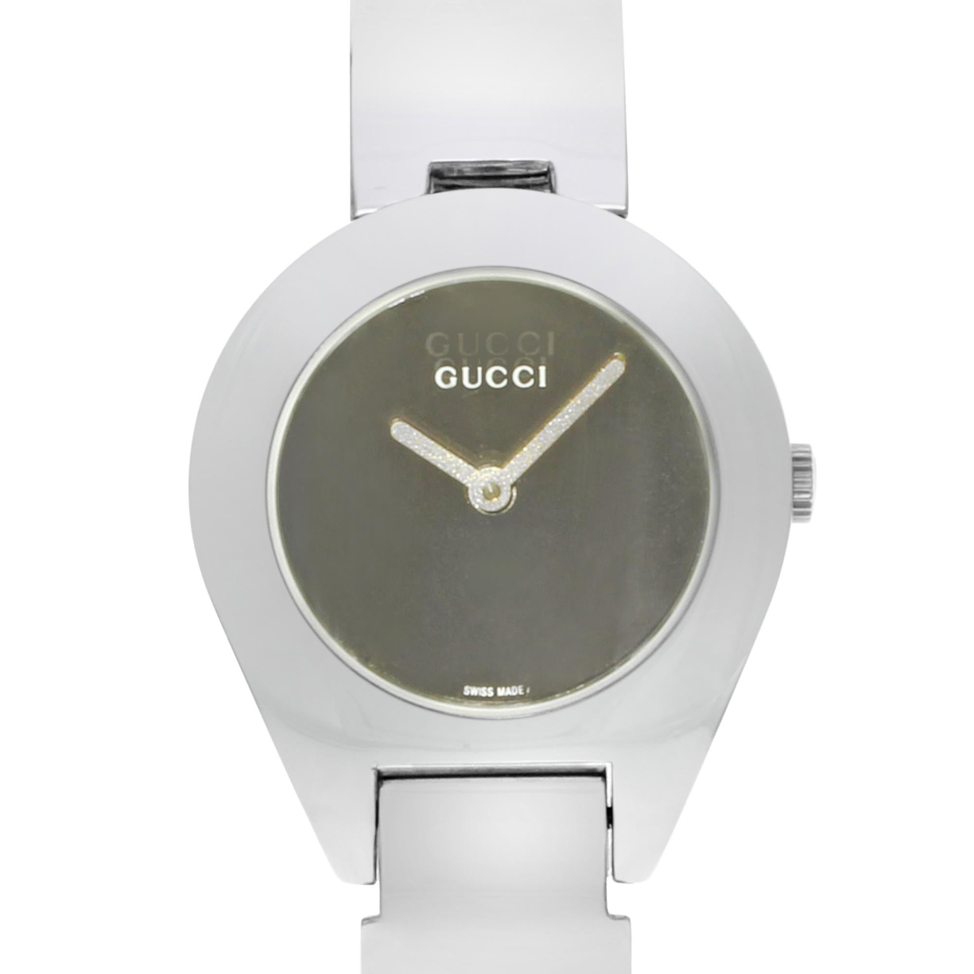 This display model Gucci 6700 L YA067504 is a beautiful Ladies timepiece that is powered by a quartz movement which is cased in a stainless steel case. It has a round shape face, no features dial and has hand unspecified style markers. It is