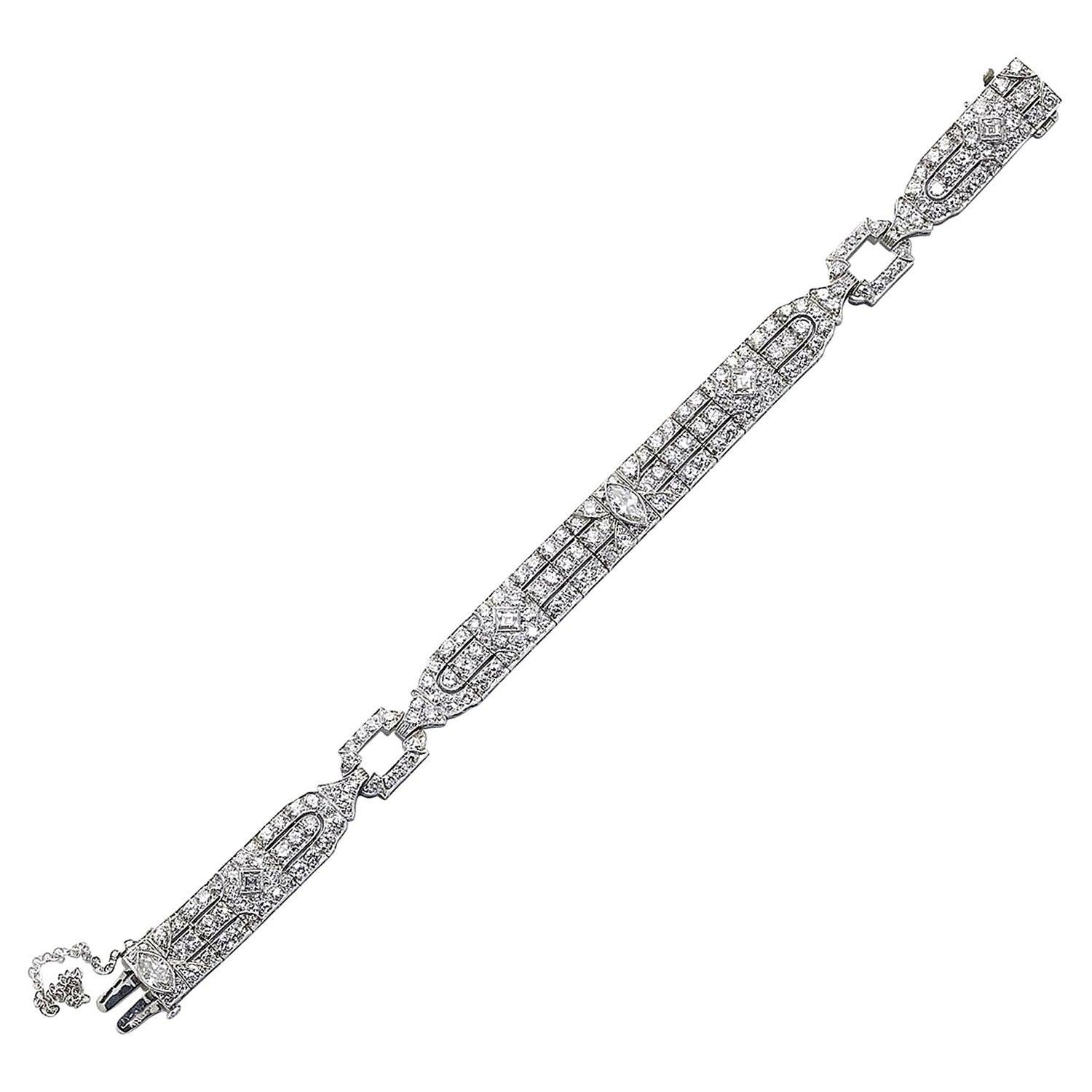 An Art Deco diamond bracelet, by Raymond Yard,  featuring two articulated panel sections, with straight sides and curved ends, with a marquise-cut diamond, rub over set, in the centre of each, flanked by old-cut diamonds, in grain settings, forming