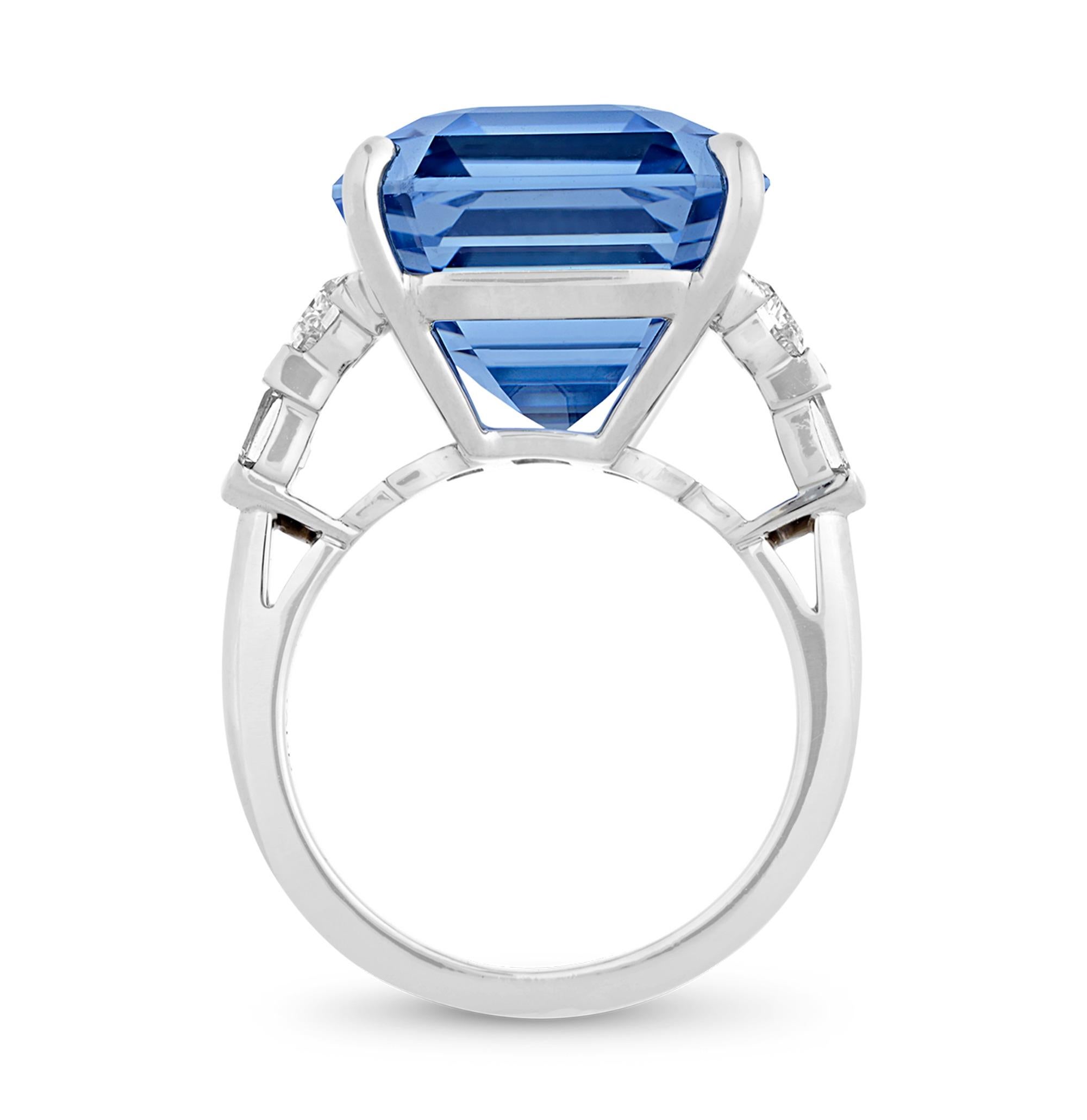 This ring centers on a breathtaking 24.90-carat sapphire from Ceylon, or Sri Lanka, a remarkable showcase of beauty and rarity. The impressive size of this GIA-certified, emerald cut sapphire highlights its breathtaking vivid violetish-blue hue.