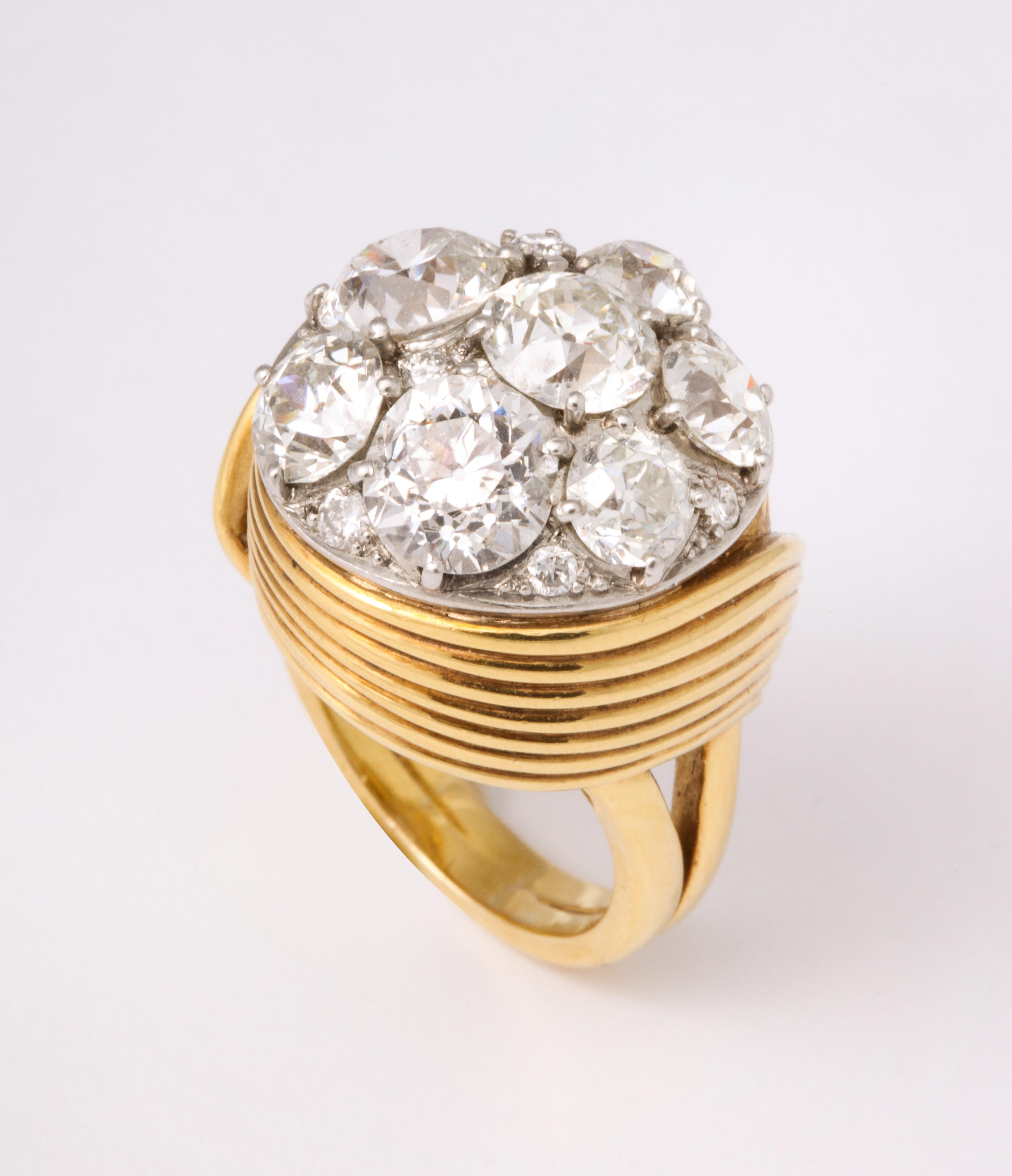 A 1940's 18K gold and diamond ring combining heritage diamonds made-to-order by famed Park Ave. society jeweler Raymond Yard designed as a sleek ribbon of ribbed gold wrapping 7 Old European cut diamonds and 9 smaller Brilliant cut diamonds. 4.88 
