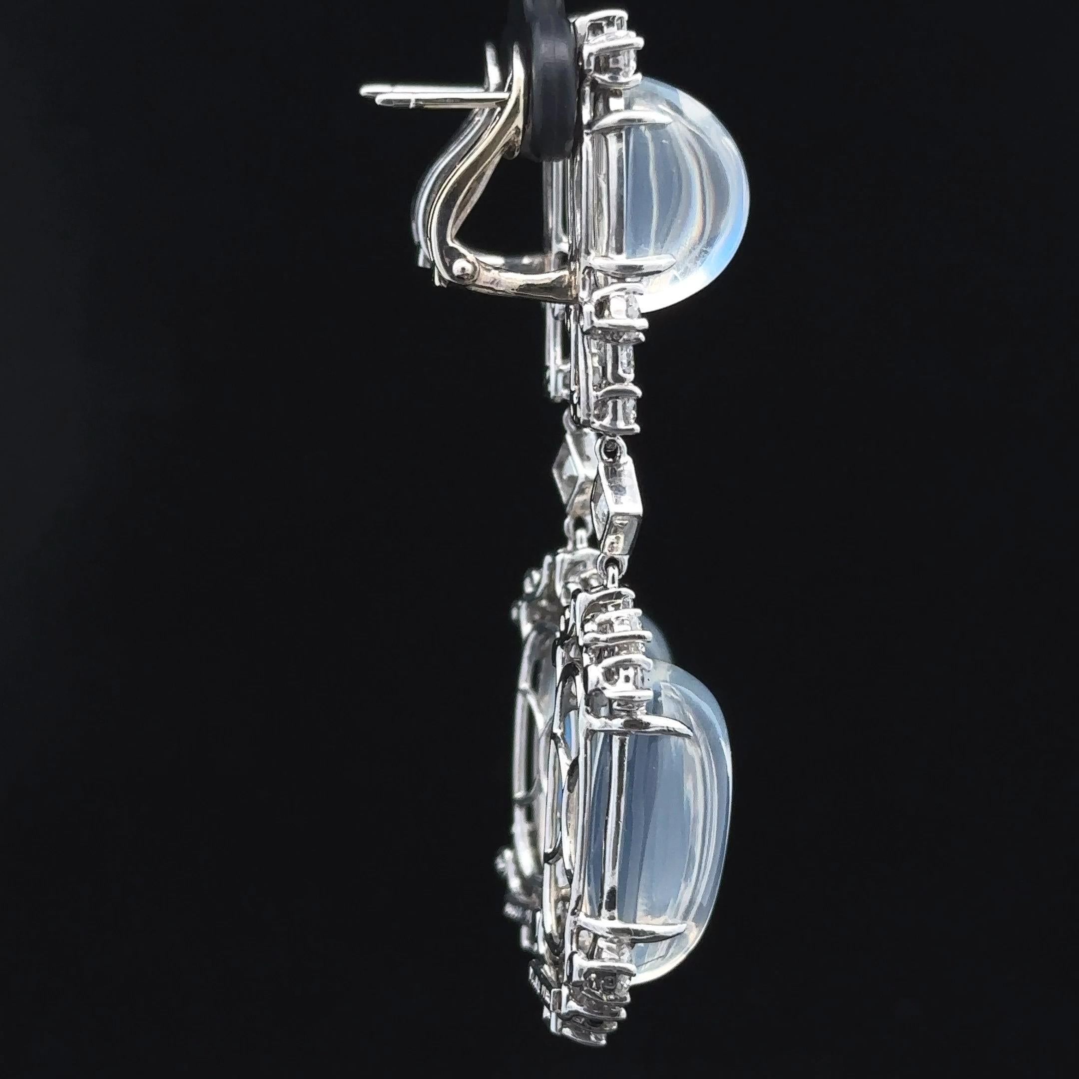 --Stone(s):--
(4) Natural Genuine Moonstones - Oval Cabochon Cut - Prong Set - Clear Base w/ Blue Hue - 13x7.9mm (at the top), 18.5x11mm (at the bottom)
Natural Genuine Diamonds - (10) Carré Cut  & Trapezoid Step Cut w/ (28) Round Brilliant Cut -