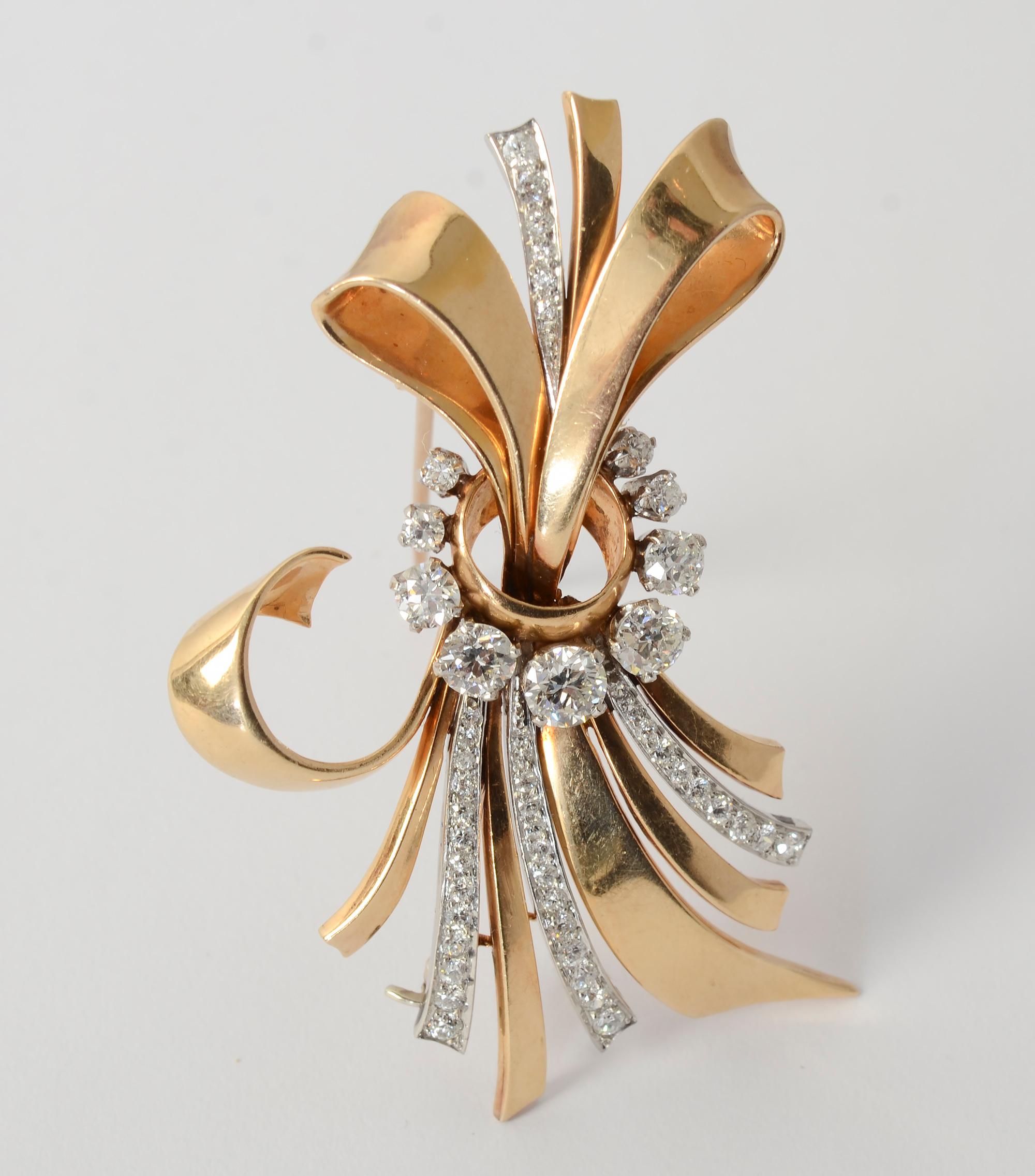 Bow design  brooch typical of the Retro era in gold, platinum and diamond  by Raymond Yard. The pin has a double stem and can be worn either vertically or horizontally. It has 3.5 carats of old European and full cut  diamonds. The stones are VVS and
