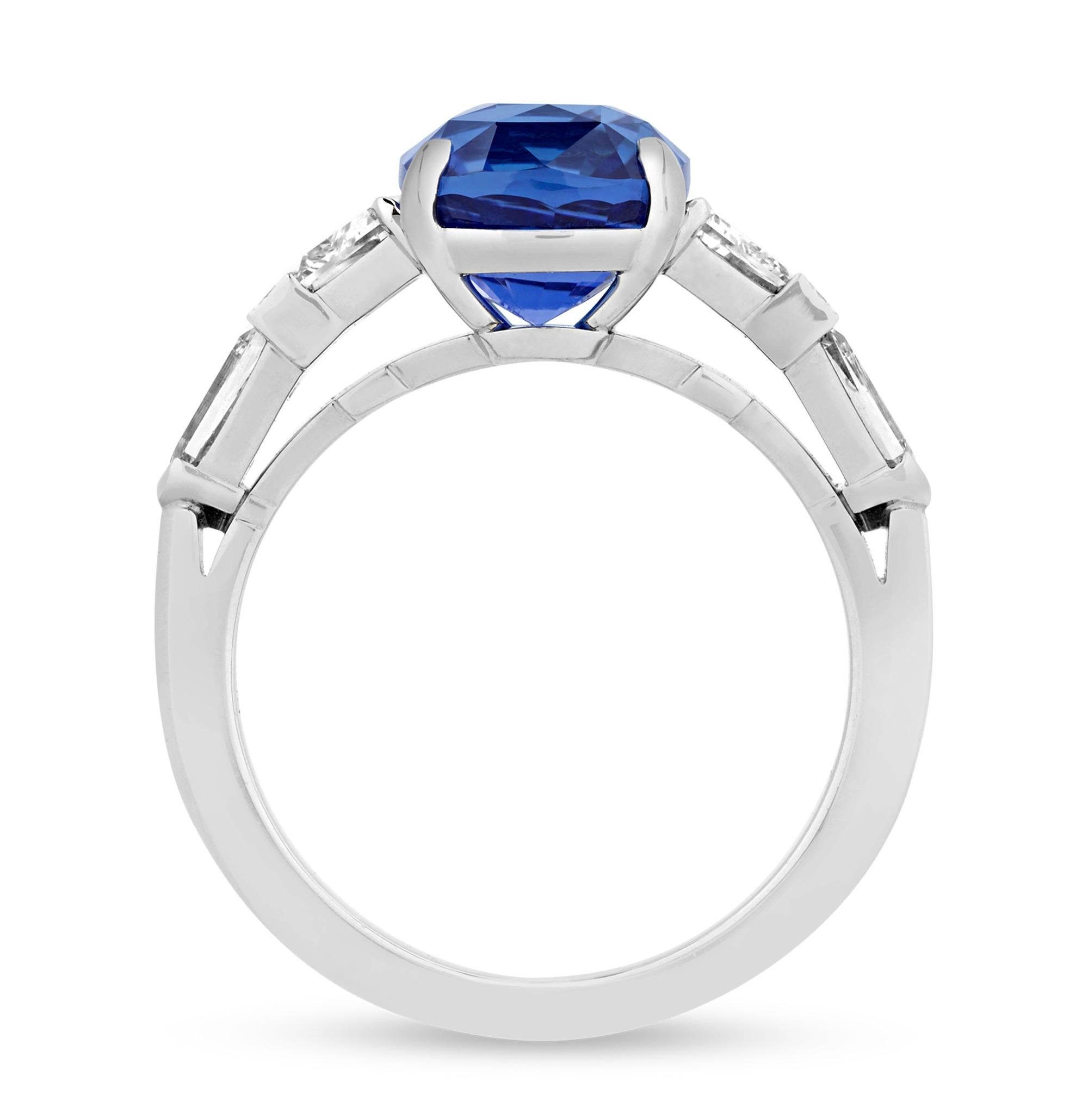 This vivid sapphire ring, designed by Raymond Yard, is a testament to the designer's unparalleled craftsmanship and innovative design ethos. The ring features an exquisite 4.60-carat cushion cut sapphire, encased in a meticulously crafted platinum