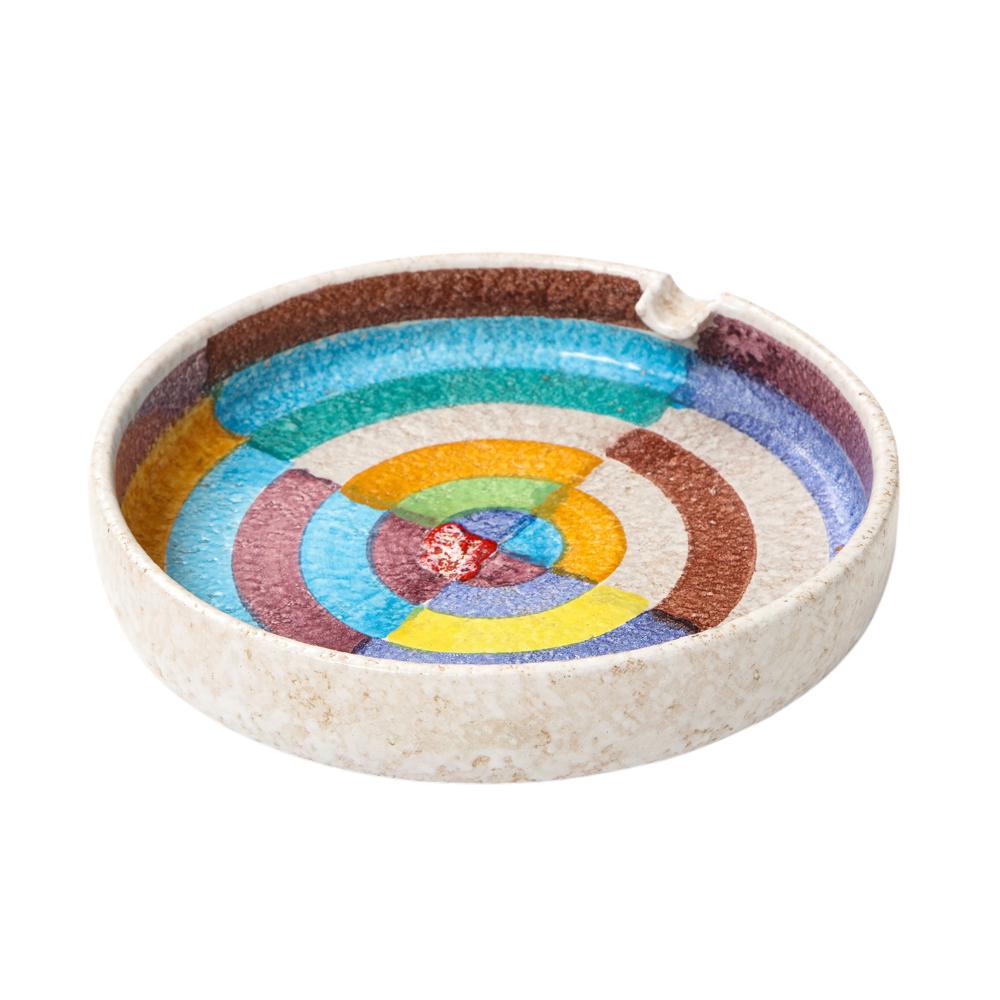 Raymor ashtray, ceramic, abstract, circular, geometric, blue, red, white, signed. Medium scale ashtray with white body and one cigarette rest, internally decorated with a circular abstract design taken directly from Robert Delaunay's 1913 painting,