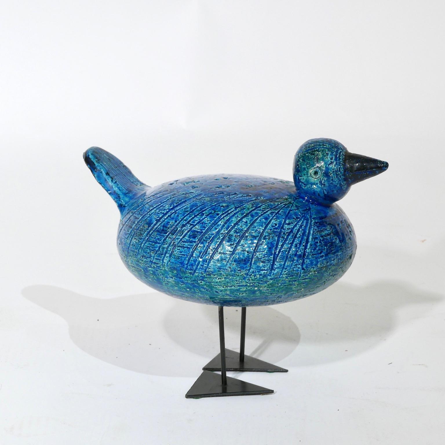 A uncommon ceramic duck glazed in blue. Designed by Aldo Londi and distributed by Raymor. Made in Italy signed. Supported by two black steel rods that attach to triangular feet.