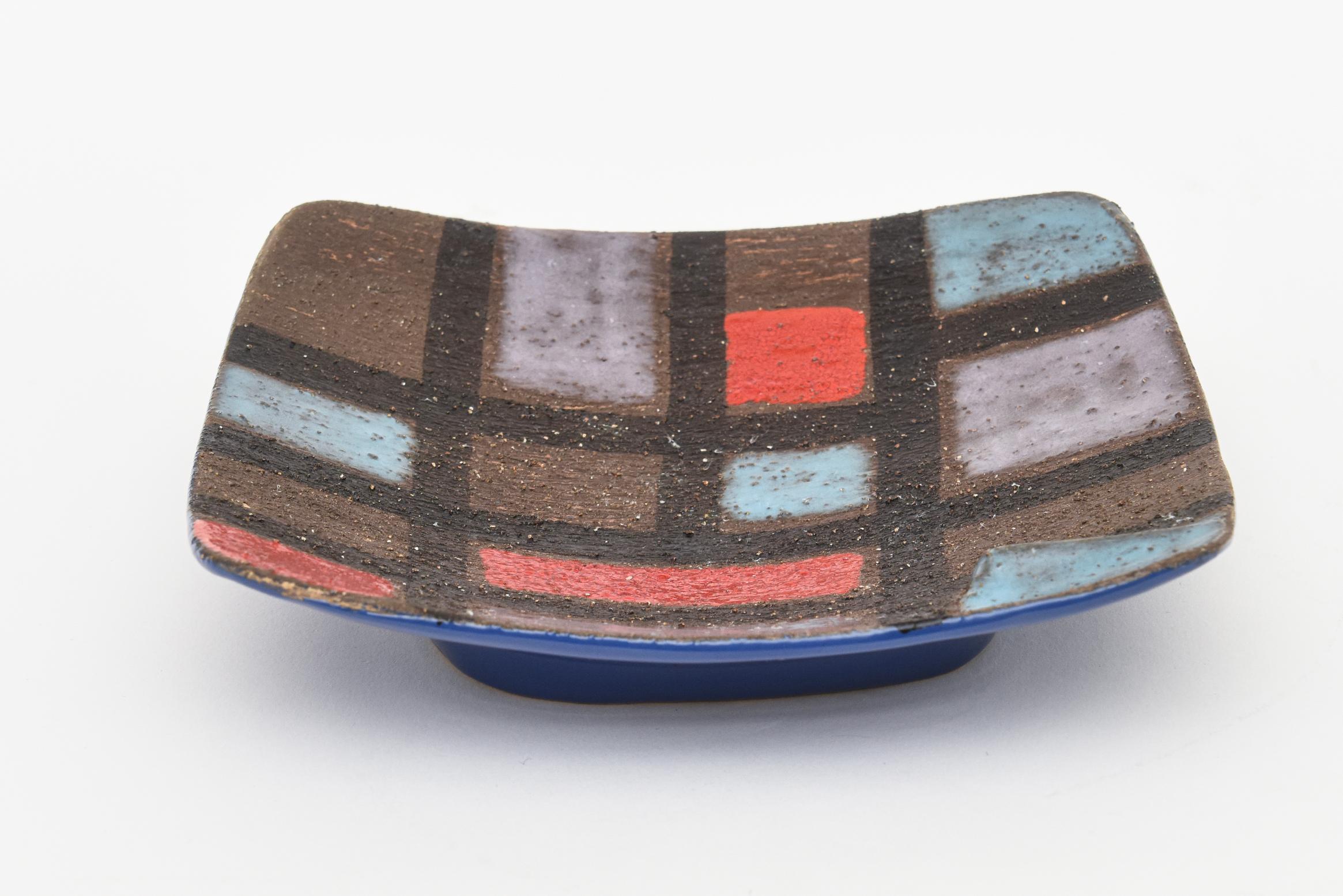 This lovely vintage Italian ceramic textural colorful patchwork bowl is signed Raymor and was designed by Bitossi. This is from the 1960s. The hallmarks on the bottom read R450-SA Raymor Italy. It is rough textured color grid of black, brown red,