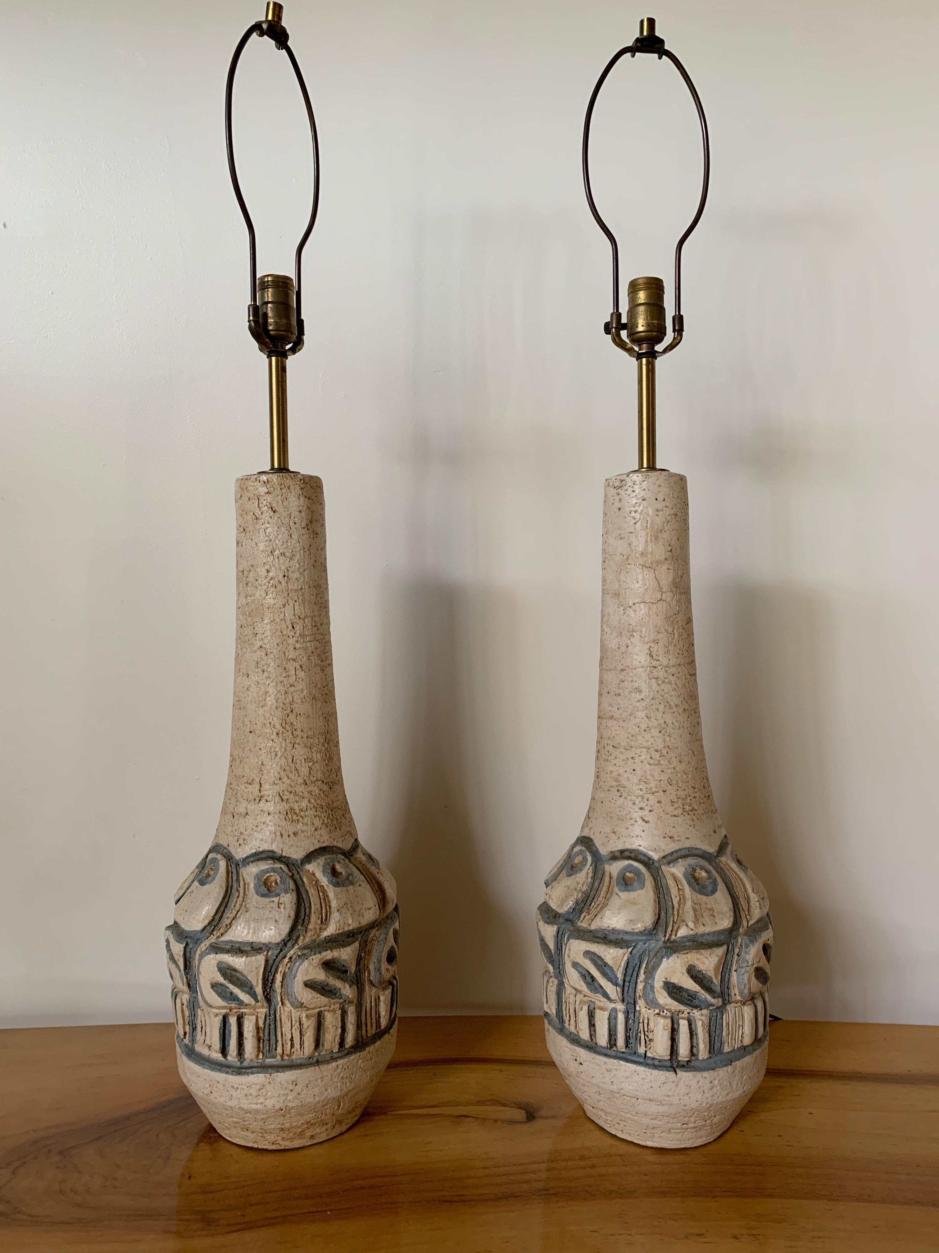 Wonderful ceramic lamps in an ecru color with deeply incised and stylized blue birds in the style of Gli Etruschi. These lamps are impressive in height with quality brass hardware. These lamps present very well.