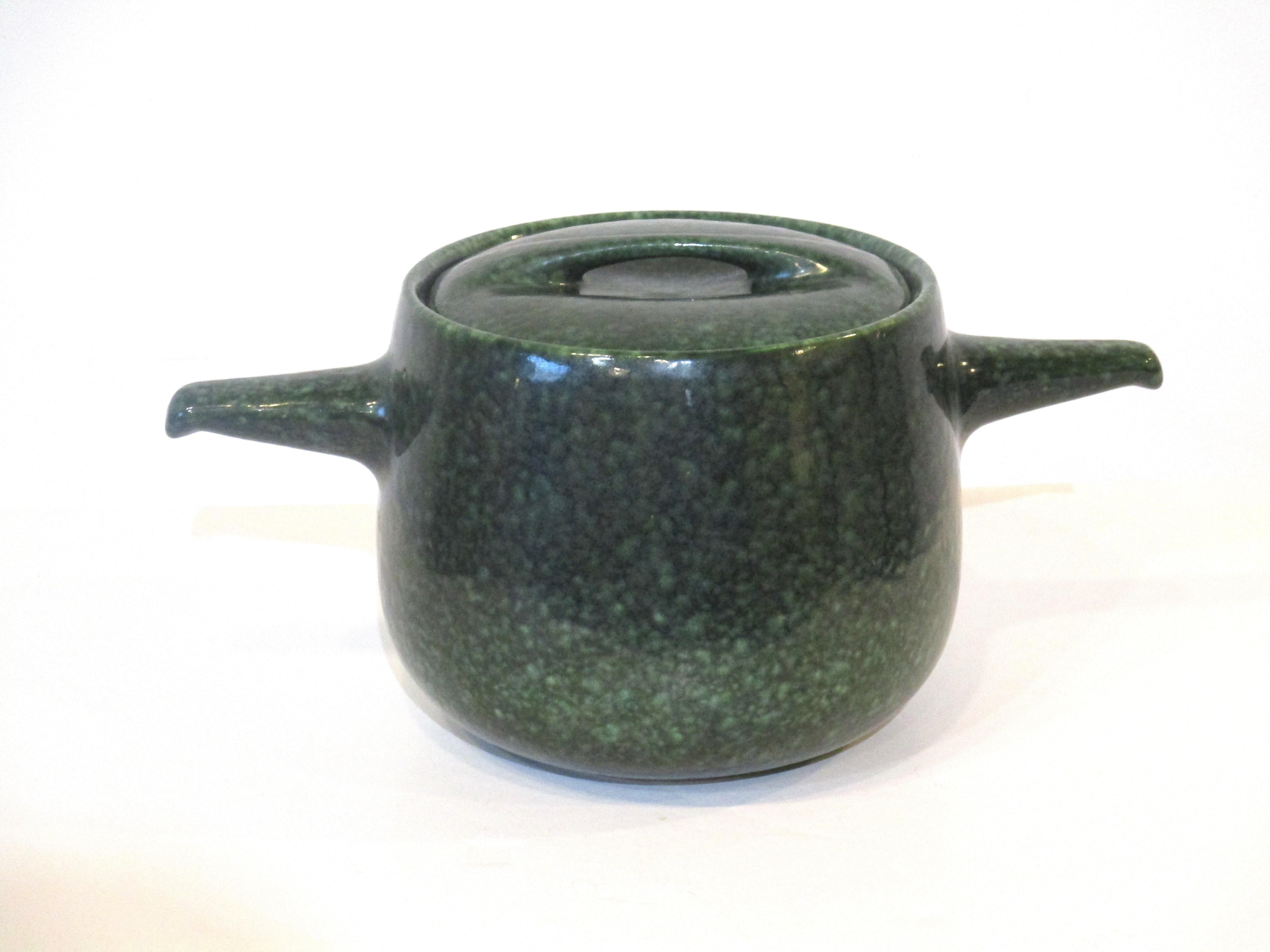 A very stylish pottery soup or serving tureen in a spotted green glaze called frog skin manufactured by the Roseville Pottery company designed by Raymor . A hard to find piece retaining the original sculptural lid .   