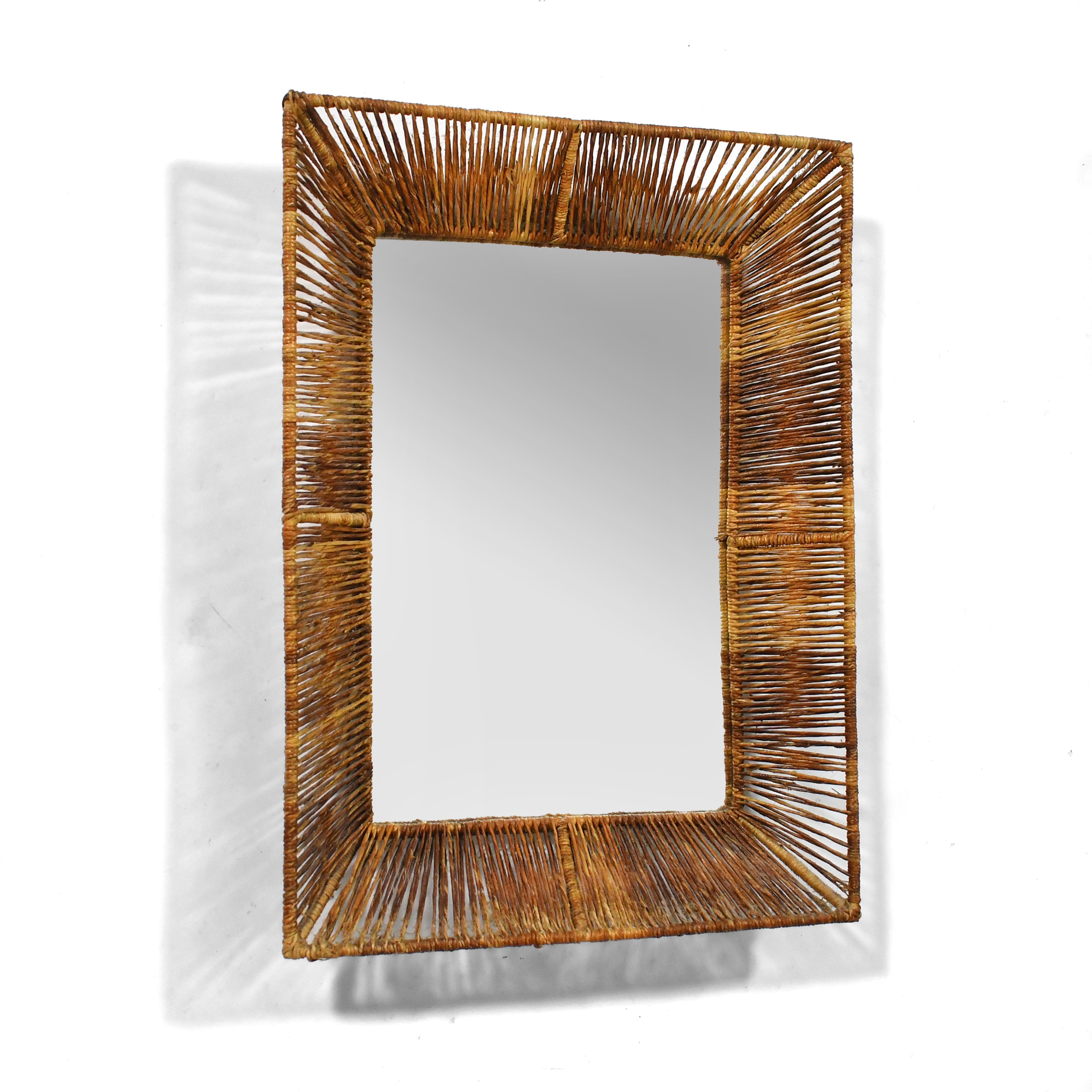 This lovely little wall mirror has an iron frame wrapped in papercord creating delightful shadow-play and giving it a wonderful texture and organic modern quality. It is marked with a Raymor label, and uses the same materials and techniques that