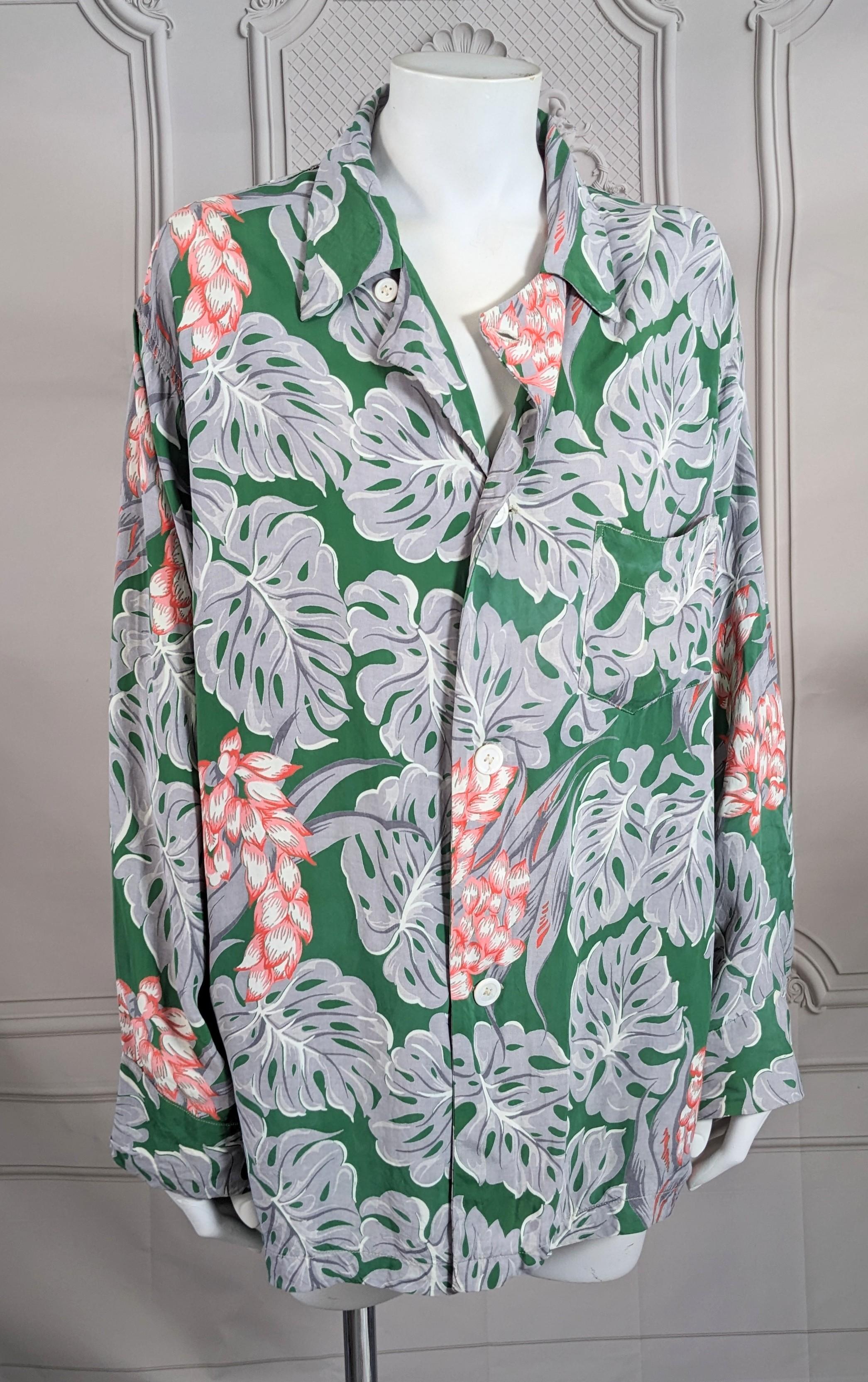 Wonderful Rayon Tropical motif printed pajama style shirt from the 1940s. Graphic Prada vibes, of huge gray and white Palm leaves with coral florals on a deep jade green background. Front button closures. Label: Faultless, by Wilson Brothers, Made