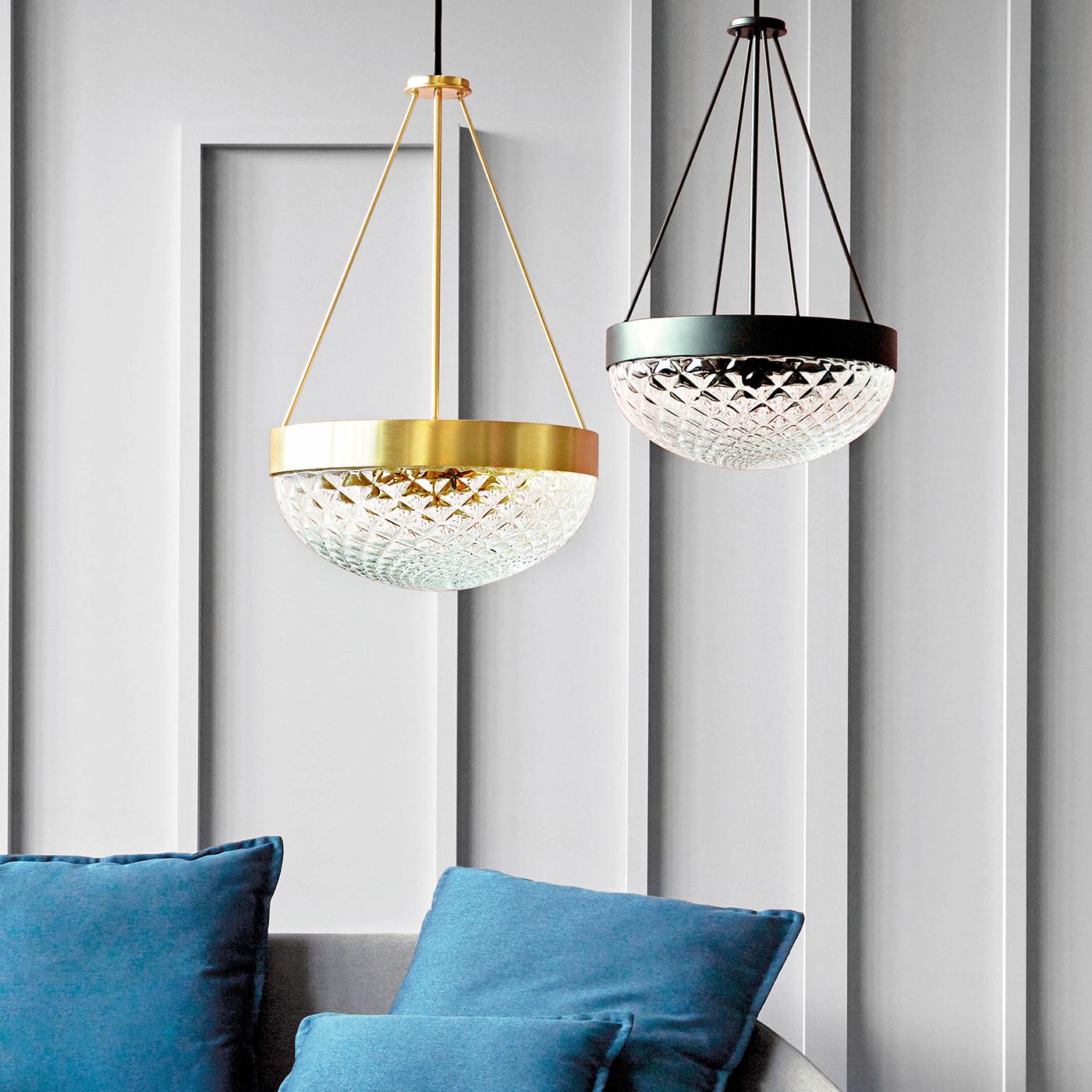Suitable as a table lamp or pendant, this eye-catching piece by Matteo Zorzenoni develops the design of a traditional ceiling lamp's lampshade and reinterprets it in a captivating, contemporary key. Hosting three light bulbs, the lampshade is in