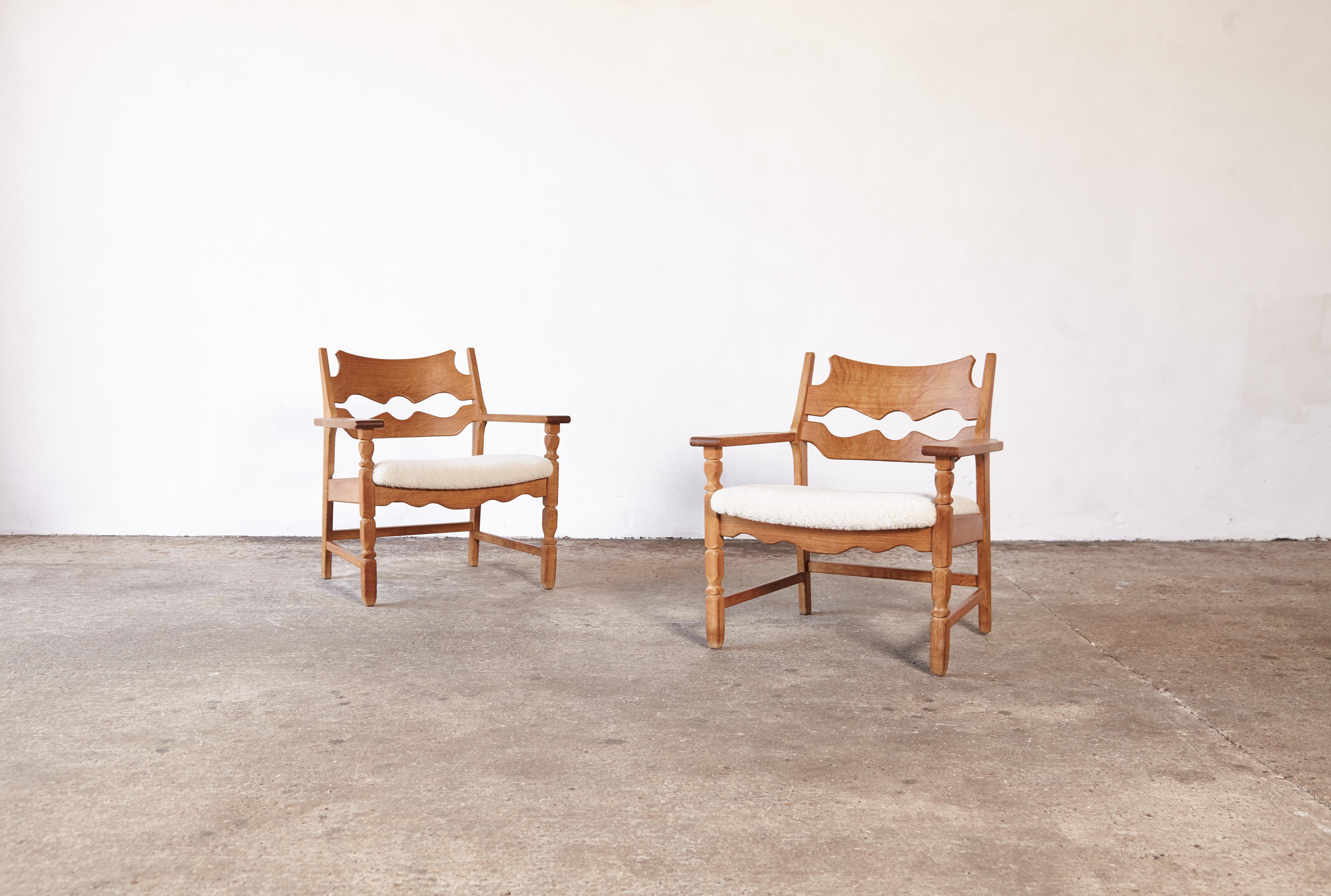 A superb pair of razor blade armchairs by Henning Kjærnulf, Denmark, 1960s. Oak frames in original condition with newly upholstered seats of sheepskin. In good condition with a nice natural patina.