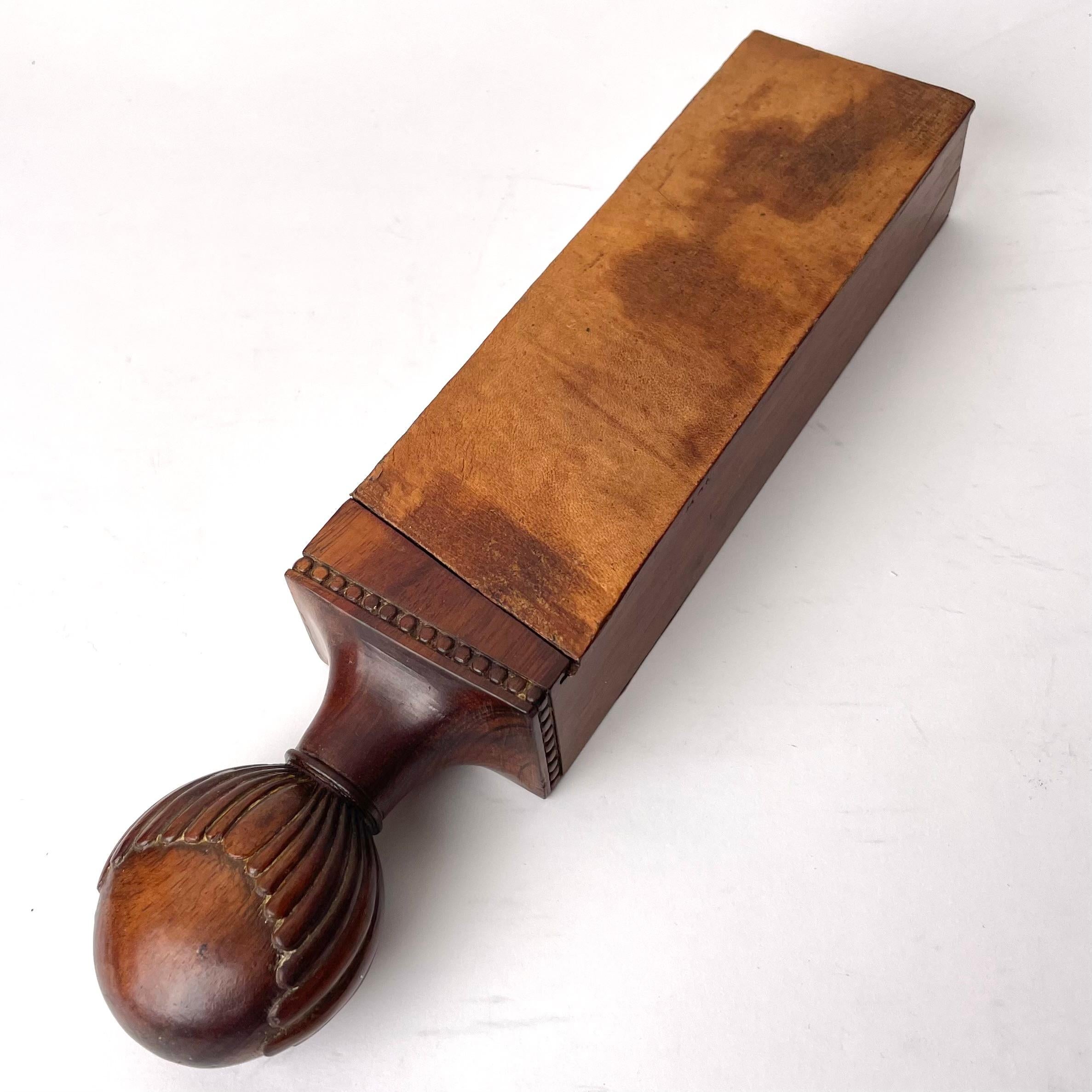 A Razor Case made of Mahogany (Swietenia mahagoni) with Razor Strap in Leather, European, Early 19th Century.

A decorative and functional razor case with an intricately detailed hilt. Complete with razor strap in leather. The inside of the box has