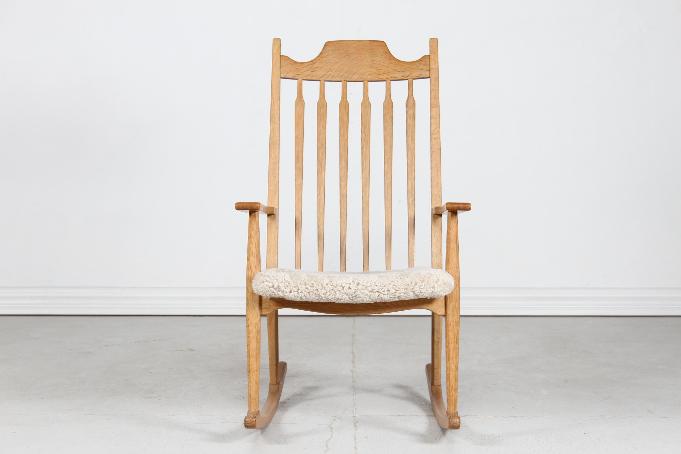 Danish vintage Henning Kjærnulf razor blade rocking chair manufactured by EG Furniture.

The chair is made of solid oak. The seat is upholstered with new sheepskin which is very comfortable and 