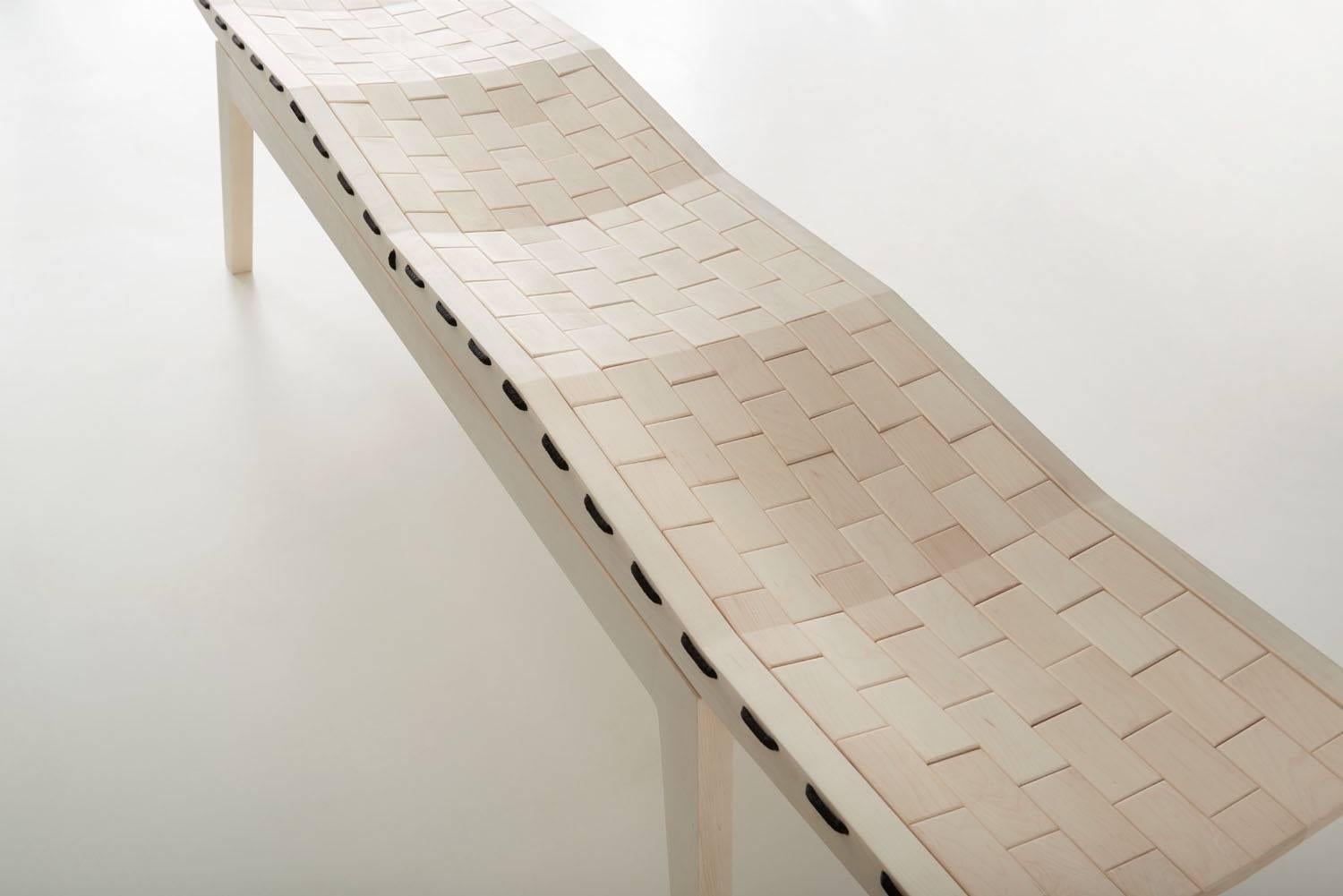 Woodsport RB bench. Named after the running bond pattern in which bricks are laid. Individual pieces of bleached maple are laced together with high grade polyester rope, creating a flexible surface that forms to the occupant. The bench is detailed