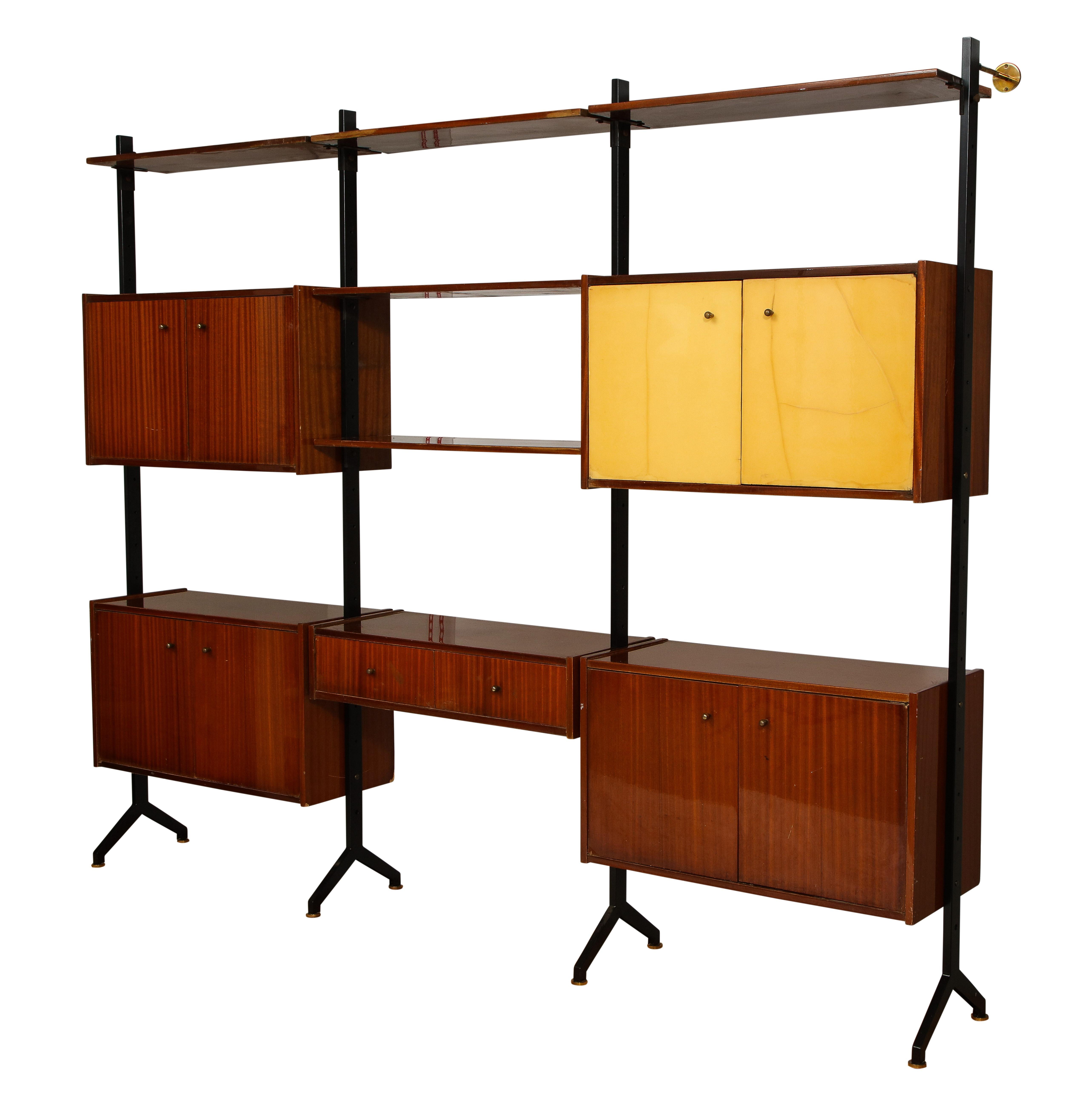 Impressive wall unit by RB Rossana in the style of Ico & Luisa Parisi. Each shelf and box unit is adjustable and can be placed at any height or on any sections. The 4 posts are enameled steel with brass feet and wall anchors. All the hardware is
