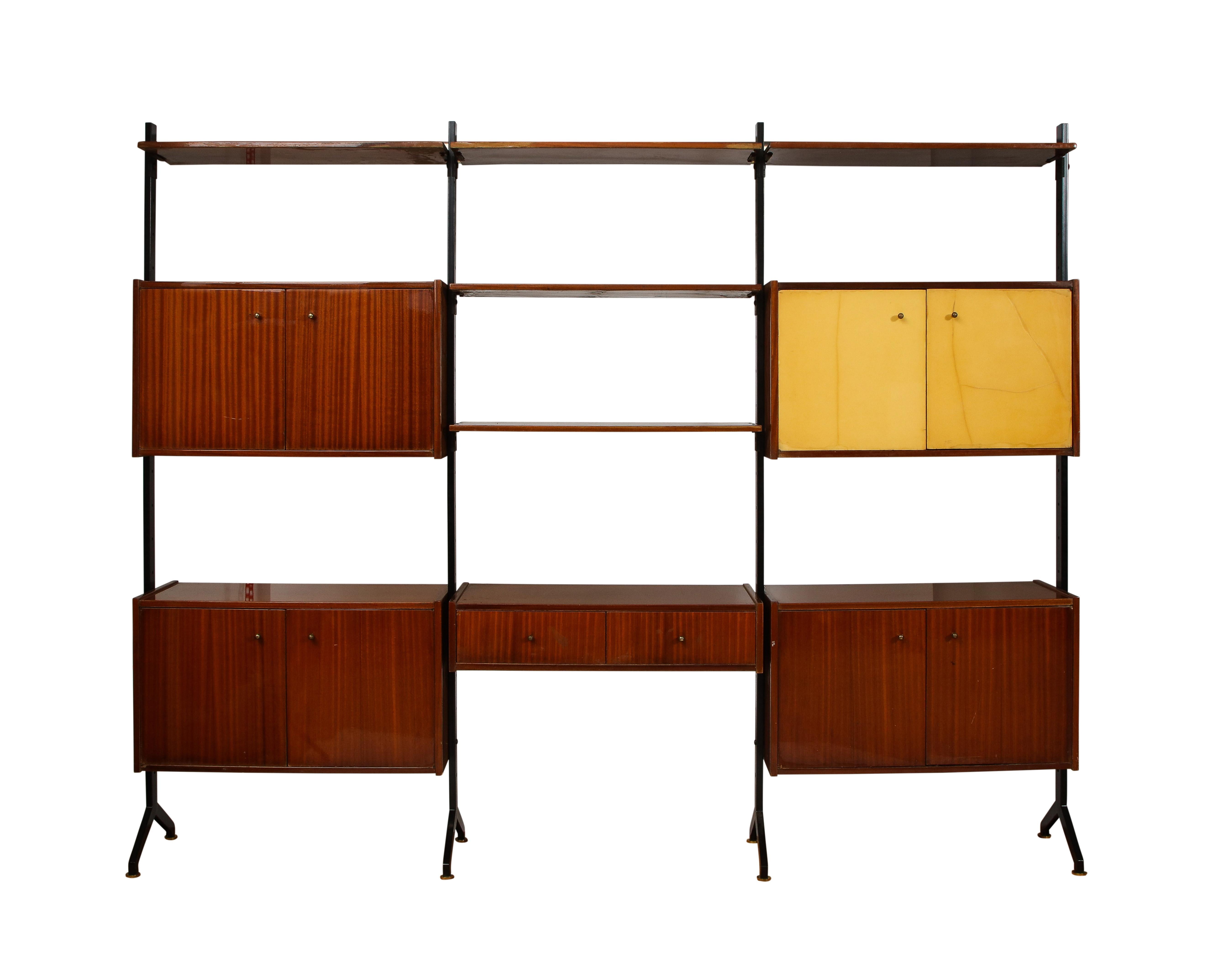Impressive wall unit by RB Rossana in the style of Ico & Luisa Parisi. Each shelf and box unit is adjustable and can be placed at any height or on any sections. The 4 posts are enameled steel with brass feet and wall anchors. All the hardware is