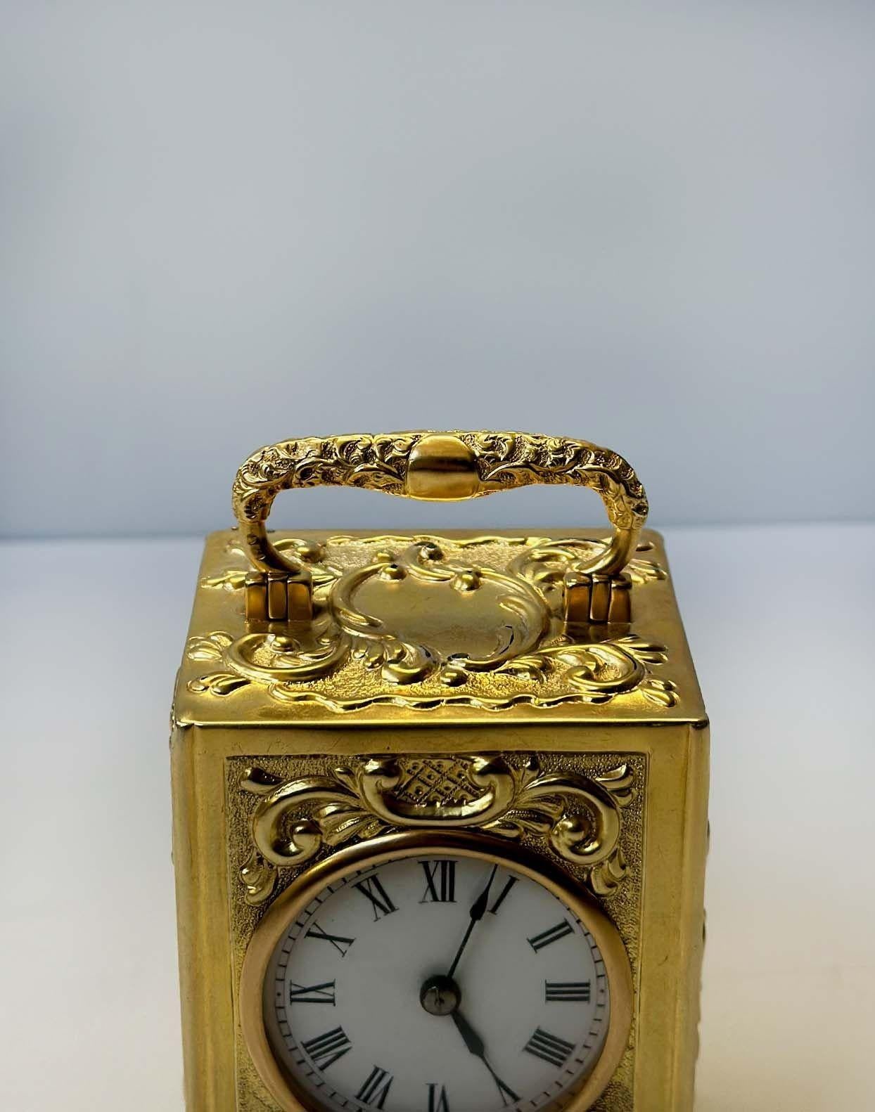 Beautiful brass carriage clock made by R&C Paris having decorated foliate scrolls all around the piece and standing on four winged beast figure feet, also having enamel dial with black Roman numerals. Stamped on the inside of the clock. Made in