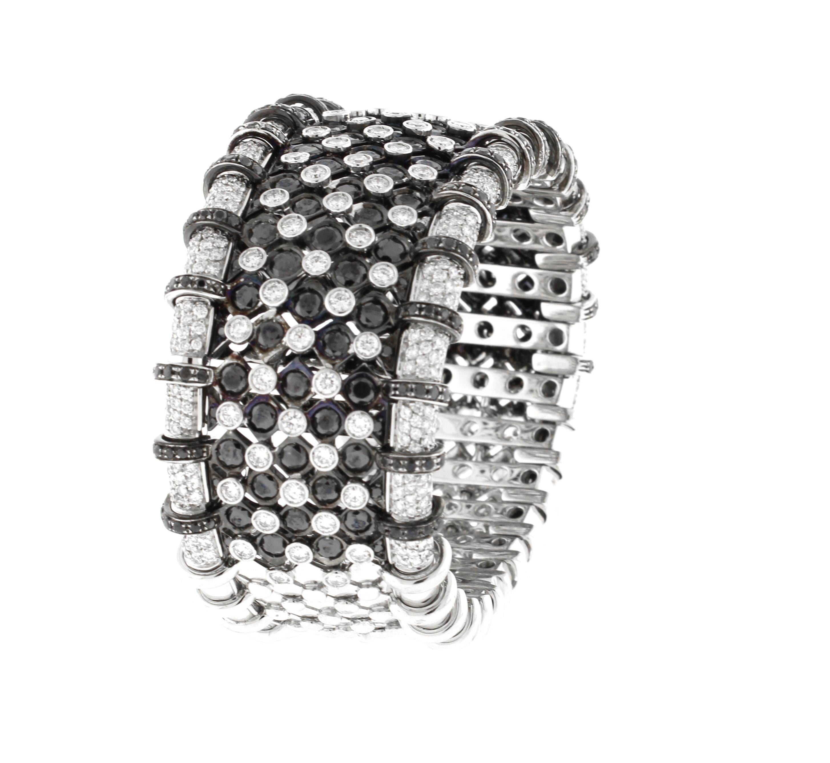 An absolutely stunning white and black diamond flexible cuff bracelet. The bangle was designed and crafted  in Valenza by master jewelers RCM Gioielli.  This outstanding bangle boasts over 9.5 carats of stunning white diamonds and 9 carats of
