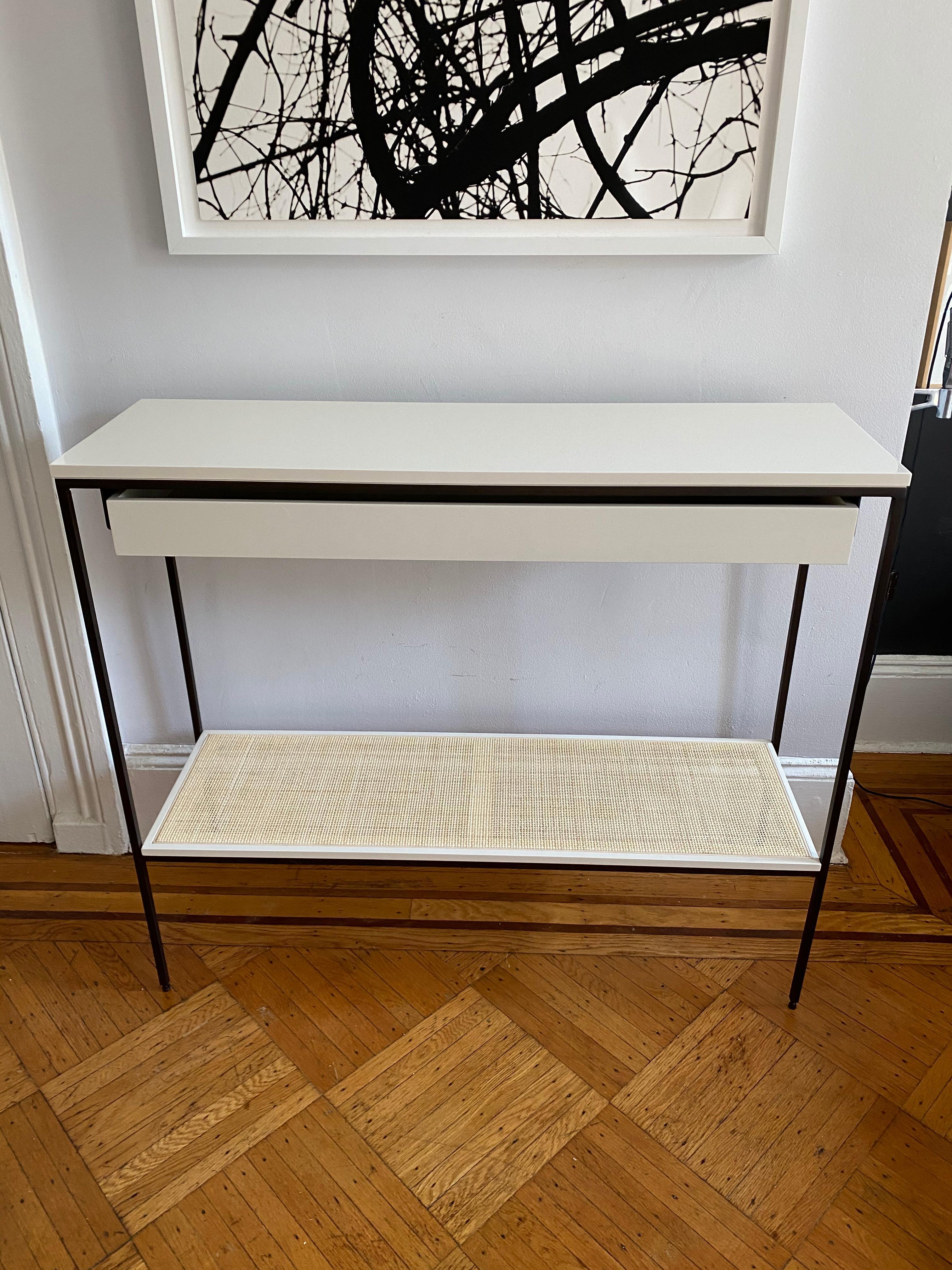 Re: 378 console table consists of lacquered components with single long drawer and caned shelf on solid oiled bronze frame. Floor model shown here in Benjamin Moore soft chamois (white) and bronze.