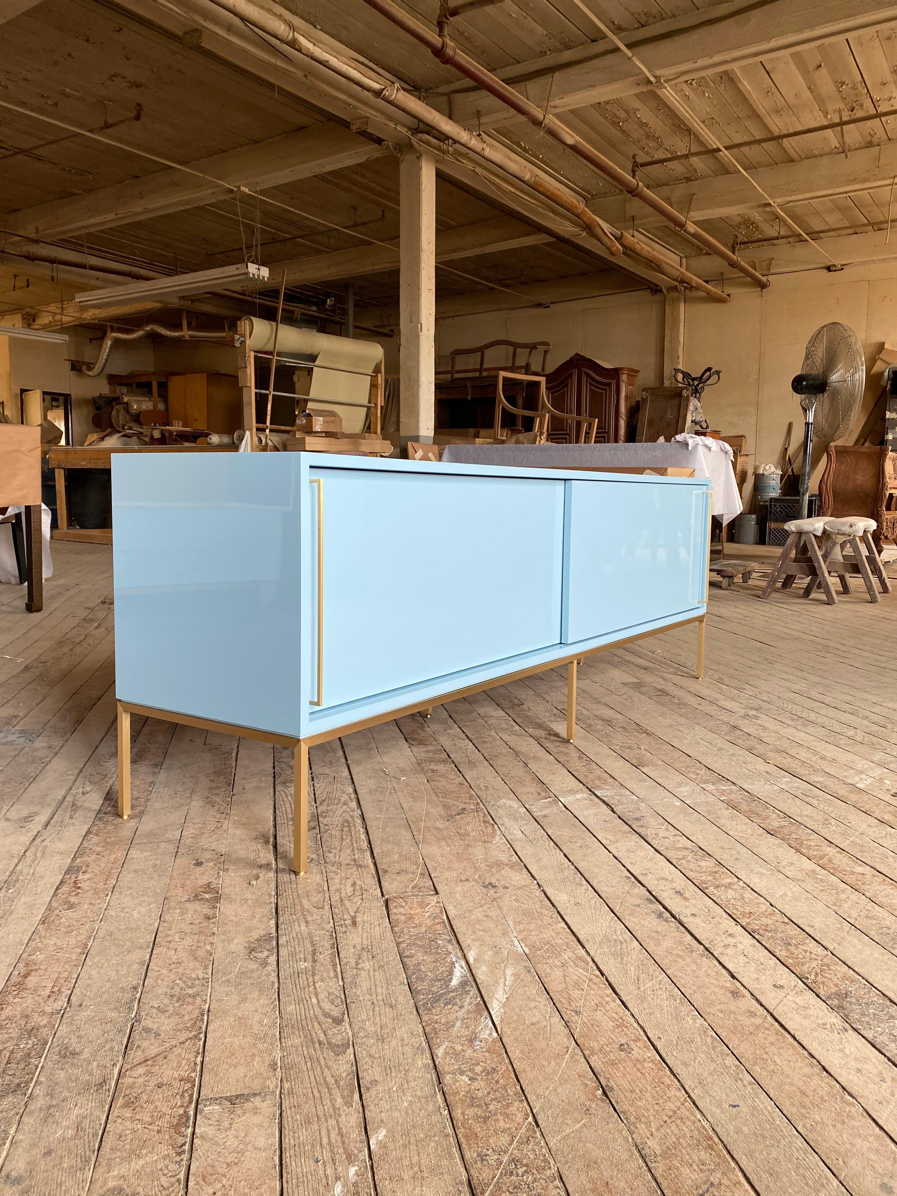 reGeneration has become known for this iconic credenza which is so versatile, clients order them again and again. It is shown here in Benjamin Moore, Marlborough blue on a handcrafted satin brass base. Sliding doors conceal two adjustable interior