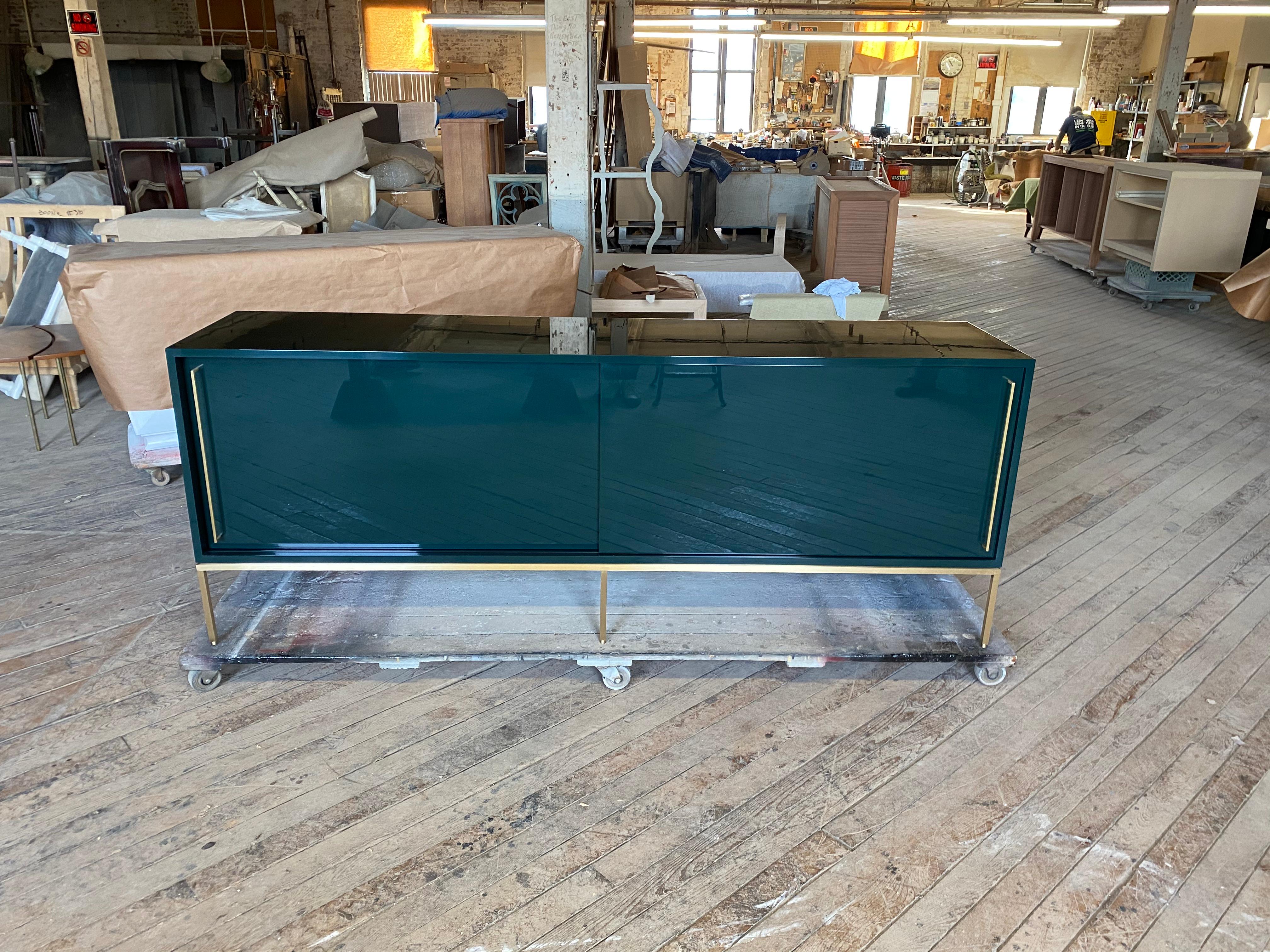 reGeneration has become known for this iconic credenza which is so versatile, clients order them again and again. It is shown here in Benjamin Moore, Essex Green on a handcrafted satin brass base. Sliding doors conceal two adjustable interior
